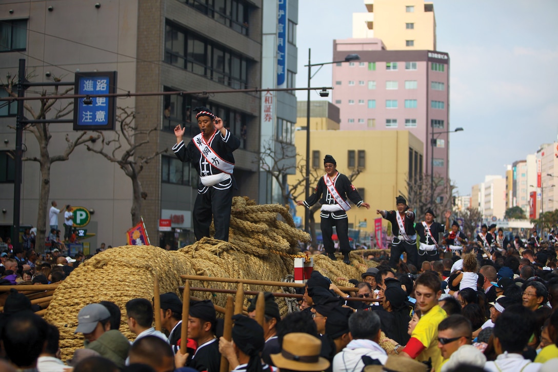 The rope is moved into place before the annual tug-of-war in downtown Naha Oct. 7. The rope, which weighs 43 tons and stretches 200 meters when assembled, is the largest in the world. Marines and sailors with the single Marine program volunteered at the event.