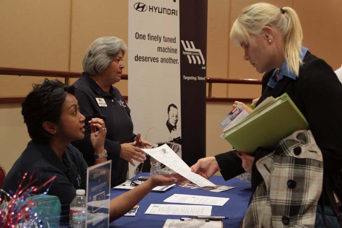 Jules Owens, a secretary for the Veterans Association of North County, explains her organization's services to Brigette L. Sparks, a military spouse from Fort Wayne, Ind., during a Military Spouse Hiring Fair hosted by the U.S. Chamber of Commerce at the Pacific Views Event Center here Oct. 11.