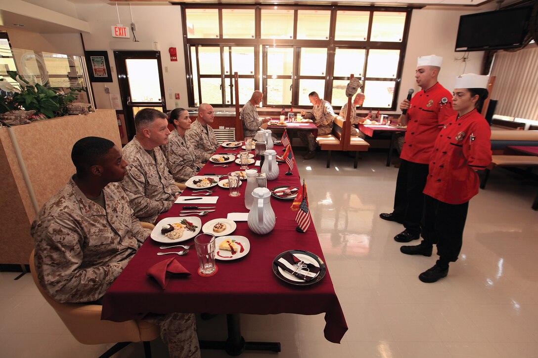Lance Cpl. Jonathon M. Sanow and Lance Cpl. Rachel A. Jurado, right, explain their meal presentation to the 3rd Marine Logistics Group command staff, which served as judges, during the Camp Kinser Mess Hall's food service specialist of the quarter competition at Camp Kinser Oct. 4. Sanow and Jurado are both food service specialists with Combat Logistics Regiment 37, 3rd Marine Logistics Group, III Marine Expeditionary Force. 