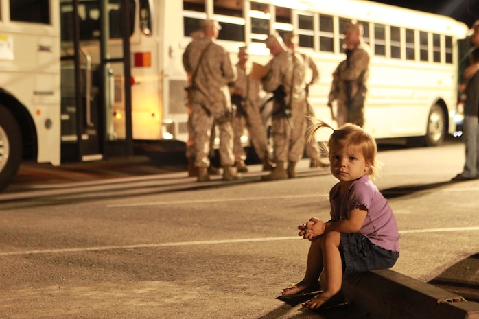 Kaydence Hoversten sits in front of buses shortly before RCT-7, 7th Marines leaves for their deployment to Afghanistan Tuesday at 7th Marine Regimental Headquarters.