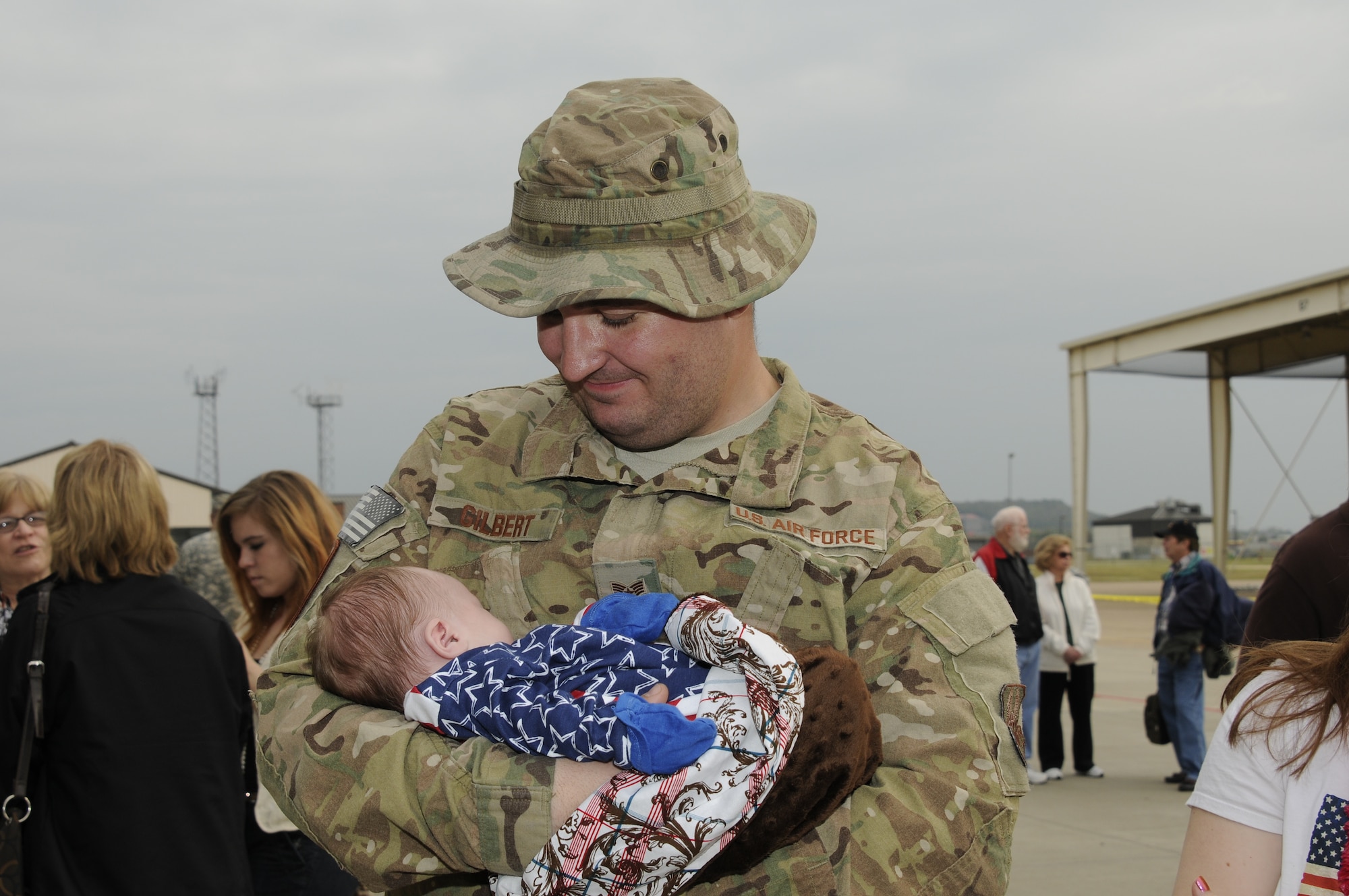 Staff Sgt. Billy Gilbert holds his son, Elijah, for the first time upon returning from a deployment to Afghanistan on Oct. 12, 2012. Approximately 280 Airmen with the 188th Fighter Wing returned to Fort Smith, Ark., from a deployment to Bagram Airfield, Afghanistan Oct. 12. (National Guard photo by Senior Airman Hannah Landeros/188th Fighter Wing Public Affairs)