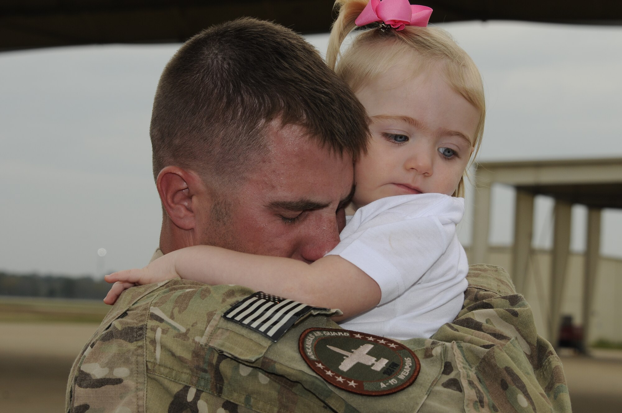 Tech. Sgt. Rick Mott squeezes his daughter upon his return from a deployment to Afghanistan on October 12, 2012. Approximately 280 Airmen with the 188th Fighter Wing returned to Fort Smith, Ark., from a deployment to Bagram Airfield, Afghanistan Oct. 12. (National Guard photo by Senior Airman Hannah Landeros/188th Fighter Wing Public Affairs)