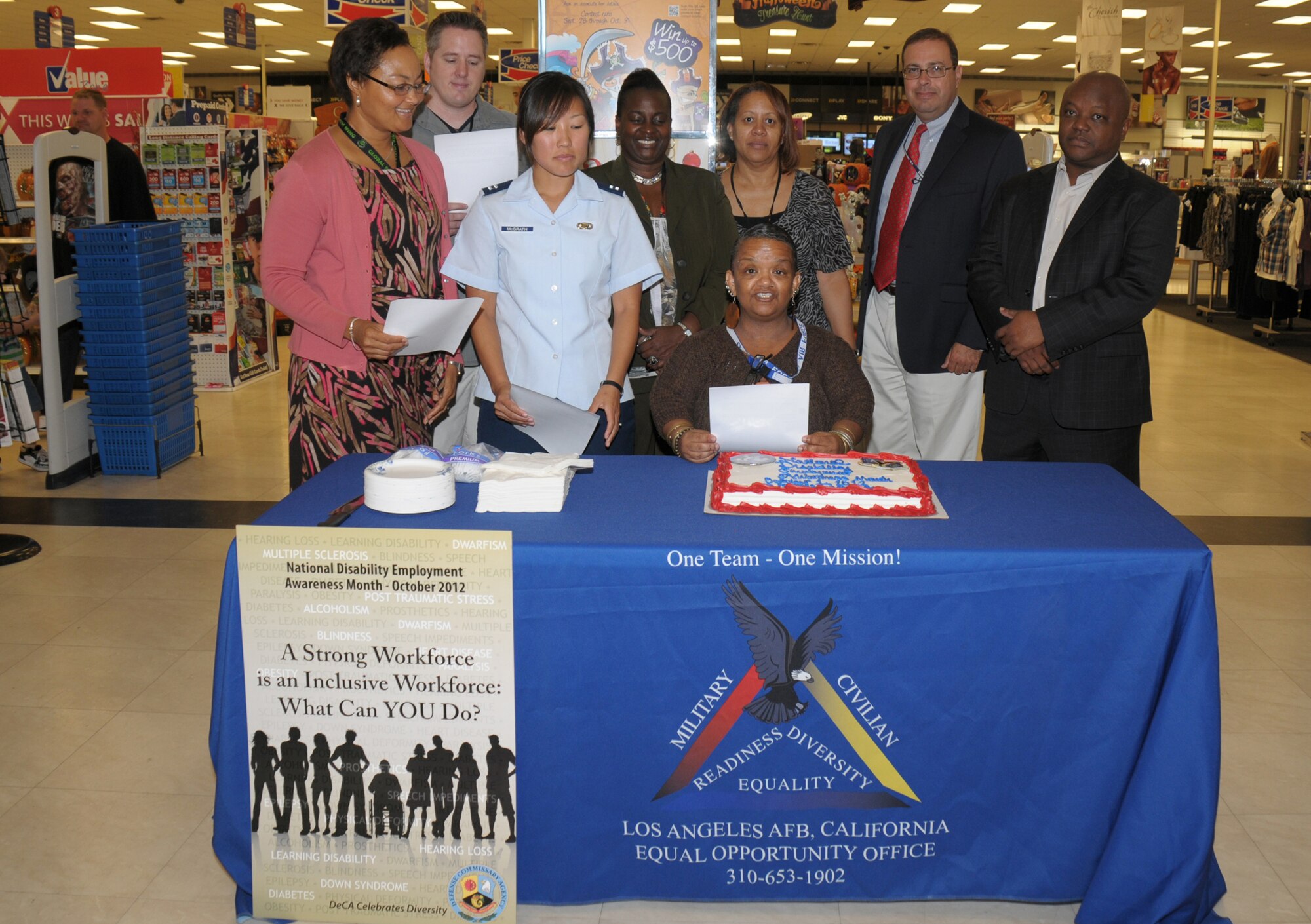National Disability Employment Awareness Month kicks off with a reading of a Presidential Proclamation and cake cutting ceremony at the Los Angeles Base Exchange, Oct. 1. Pictured left to right are: Valerie Robinson, Corey Webber, Capt. Meo McGrath, Nina Smith, Myra Ford, Linda Vanifh, Augustin Velez and Tommy McInnis.  (Photo by Joe Juarez)