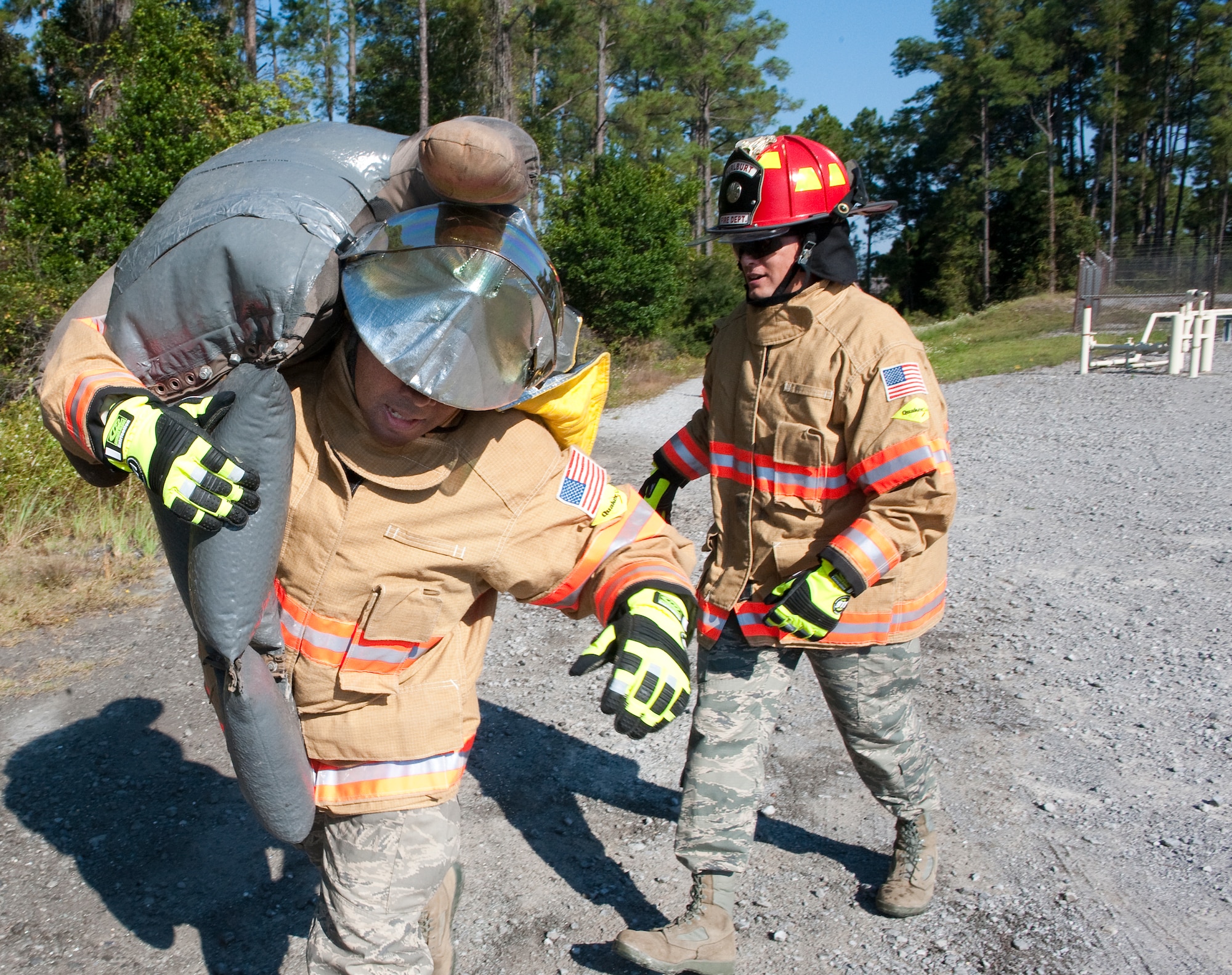 U.S. Air Force Chief Master Sgt. Brian Richardson, command chief of 1st Special Operations Mission Support Group (left) and Col. Douglas Dudley, commander of 1st SOMSG, work together to carry a 75-pound mannequin to safety during training on Hurlburt Field, Fla., Oct. 11, 2012. The Hurlburt Field Fire Department gave its first-ever crash course on the firefighter?s daily training regiment to the 1st SOMSG squadron leadership. (U.S. Air Force photo/Airman 1st Class Christopher Williams)