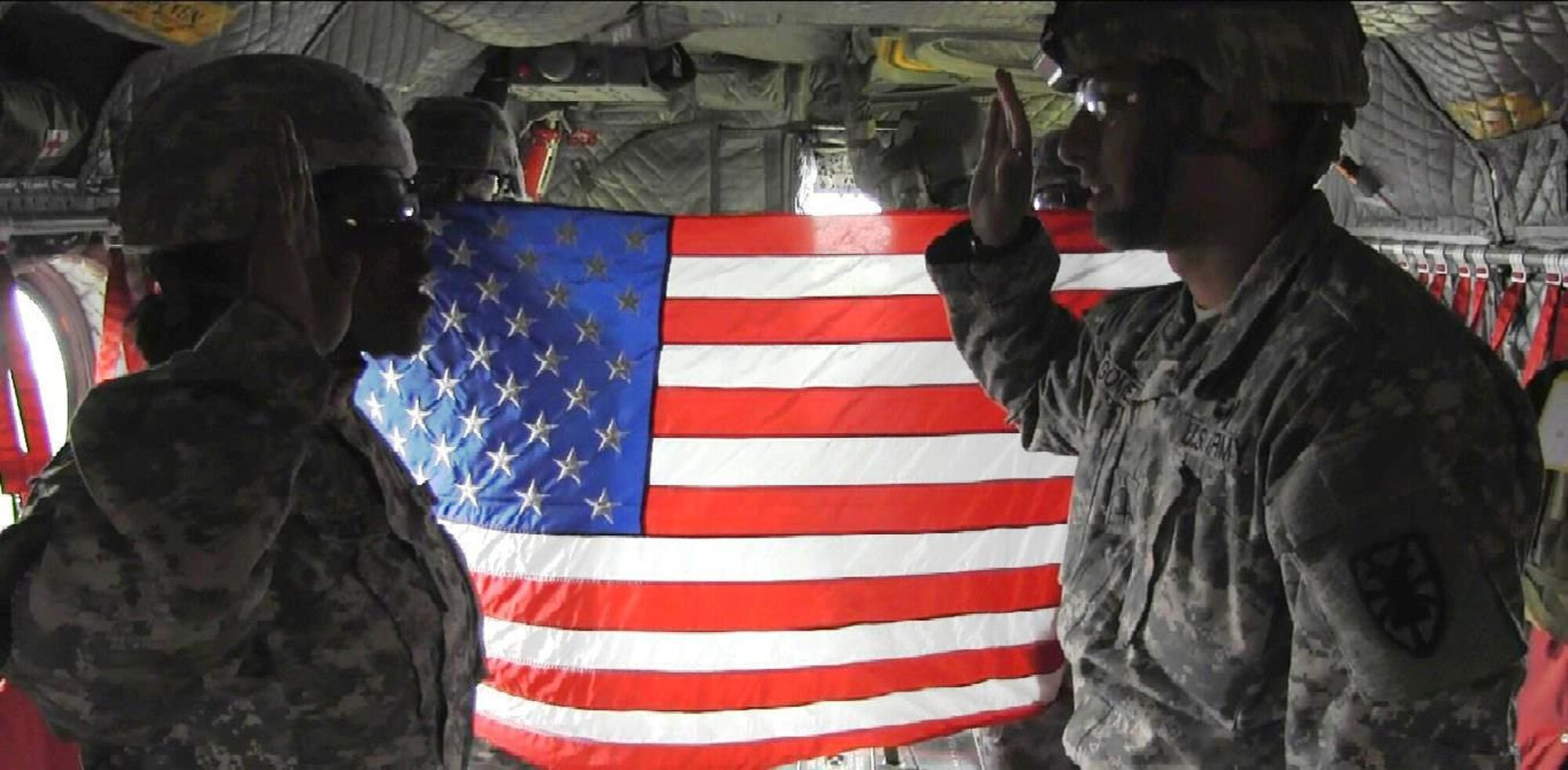 U.S. Army Spc. Tequana Marcelle, left, an automated supply specialist assigned to the 567 Inland Cargo Transfer Company, 53 Movement Control Battalion, 7 Sustainment Brigade, re-enlists while in flight on a Chinook helicopter above Felker Army Airfield at Fort Eustis, Va., recently. Tequana said he enjoys his job, and wants to continue his military career. (U.S. Army photo by Sgt. 1st Class Brian Rhodes/Released)