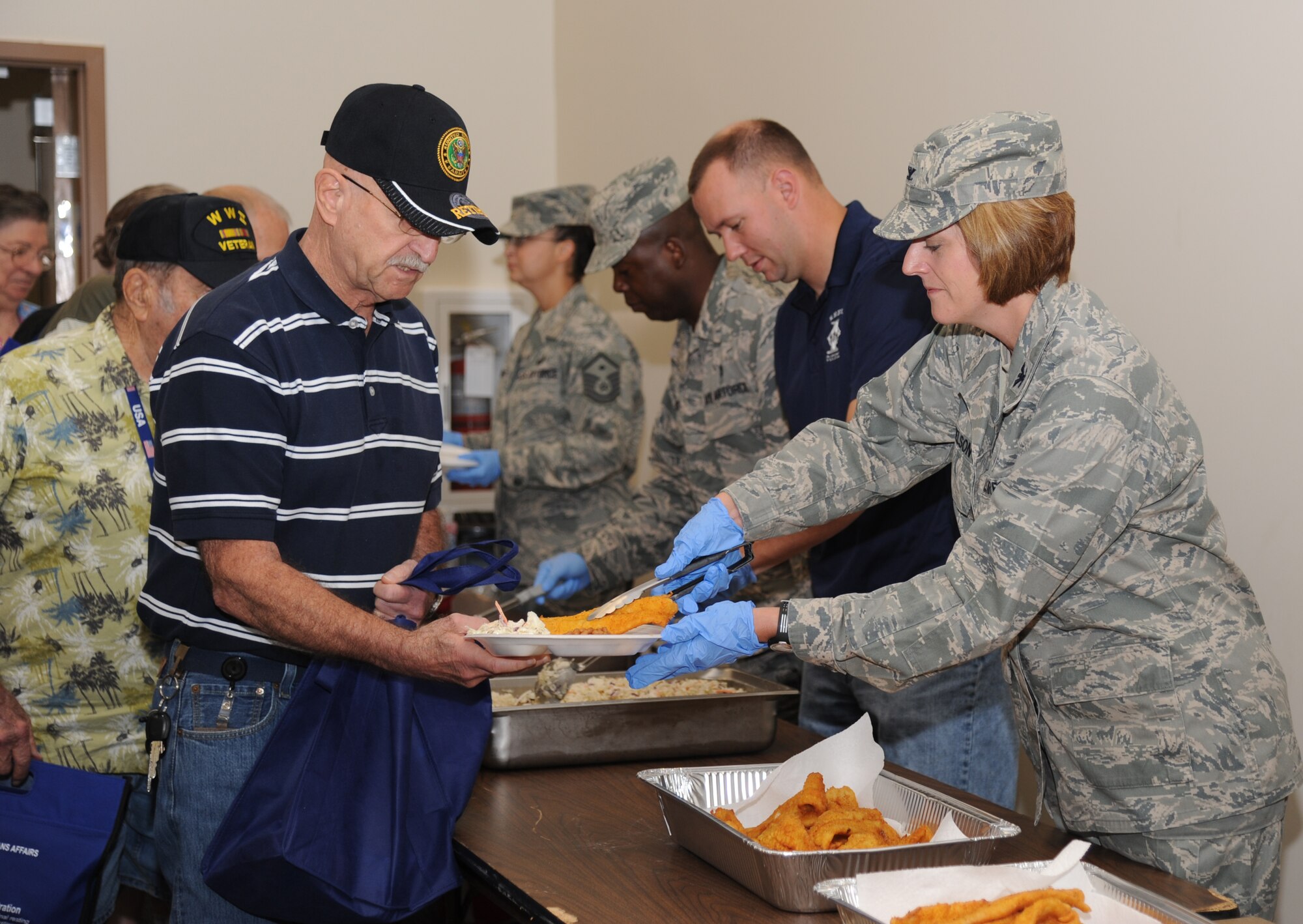 Retired Army Sgt. 1st Class Edward Sousa of Gulfport, Miss., is served fried cat fish by Col. Cathy Nelson, 81st Medical Group, during retiree appreciation day Oct. 12, 2012, at the Roberts Consolidated Aircraft Maintenance Facility, Keesler Air Force Base, Miss.  The event included information booths, guest speakers and lunch.  (U.S. Air Force photo by Kemberly Groue)