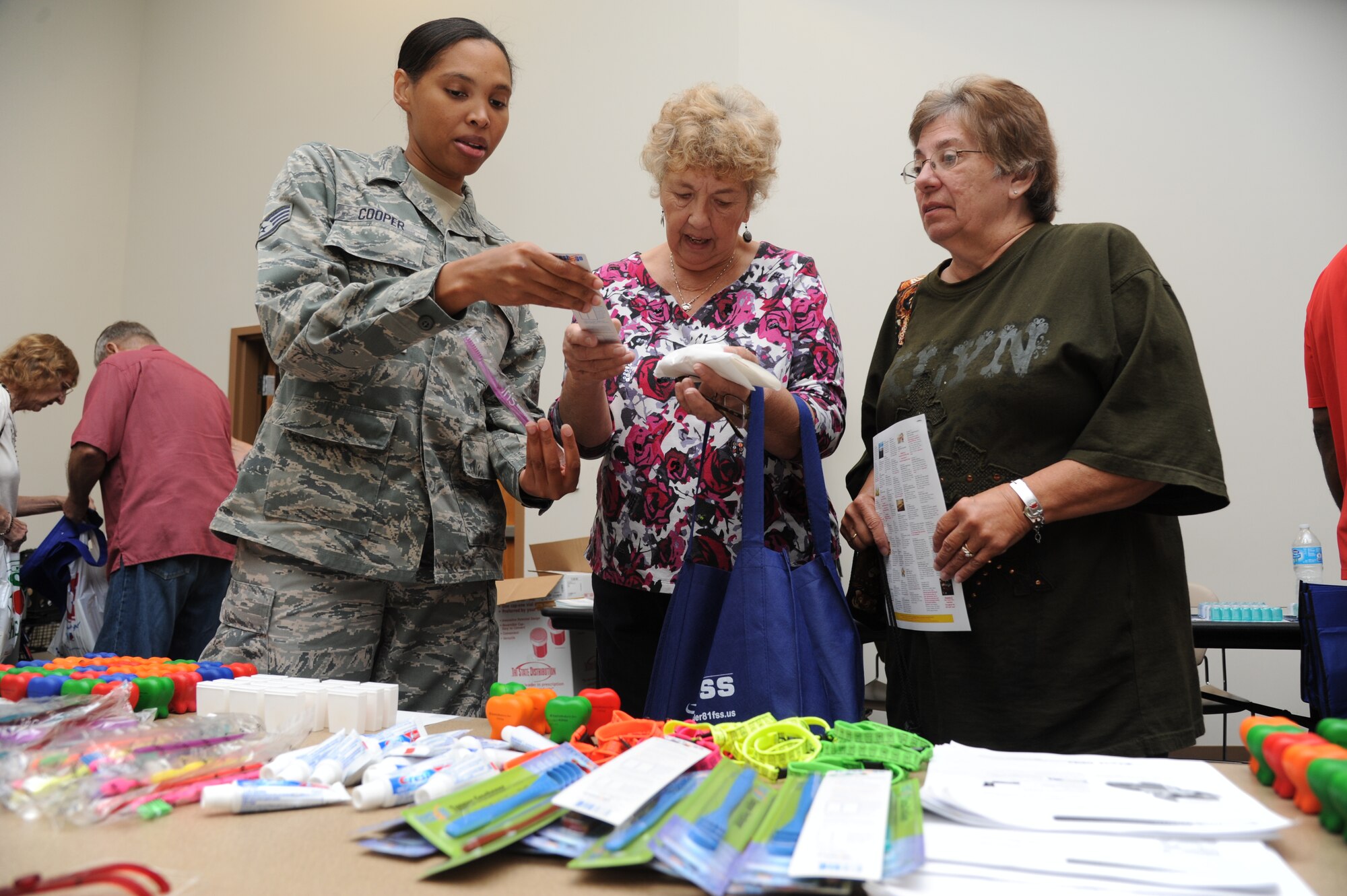Staff Sgt. Chique Cooper, 81st Dental Squadron, hands out dental products to Elsie Rausch, wife of retired Tech. Sgt. Paul Rausch of Perkinston, Miss., and Cheryl Partin, daughter-in-law of retired Master Sgt. Charles Partin, of St. Martin, Miss., during the 81st Training Wing’s retiree appreciation day Oct. 12, 2012, at the Roberts Consolidated Aircraft Maintenance Facility, Keesler Air Force Base, Miss.  The event included information booths, guest speakers and lunch.  (U.S. Air Force photo by Kemberly Groue)