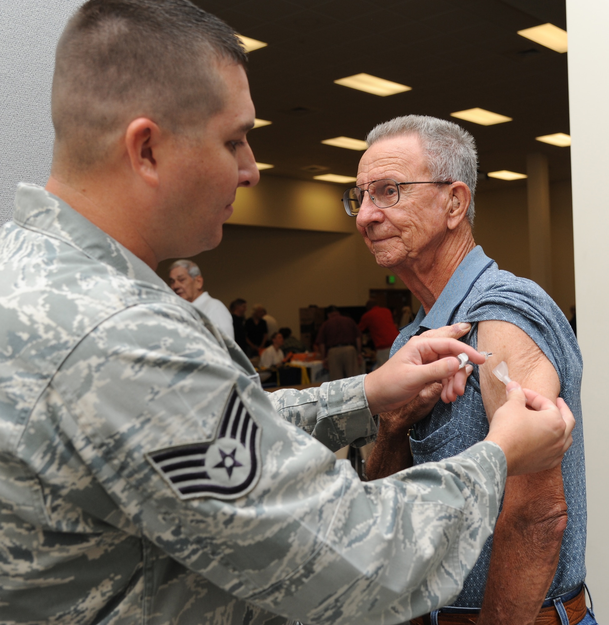 Staff Sgt. James Bowden, 81st Medical Operations Squadron, administers a flu shot on retired Tech. Sgt. Ben Williams of Biloxi, Miss., during the 81st Training Wing’s retiree appreciation day Oct. 12, 2012, at the Roberts Consolidated Aircraft Maintenance Facility, Keesler Air Force Base, Miss.  The event included information booths, guest speakers and lunch.  (U.S. Air Force photo by Kemberly Groue)