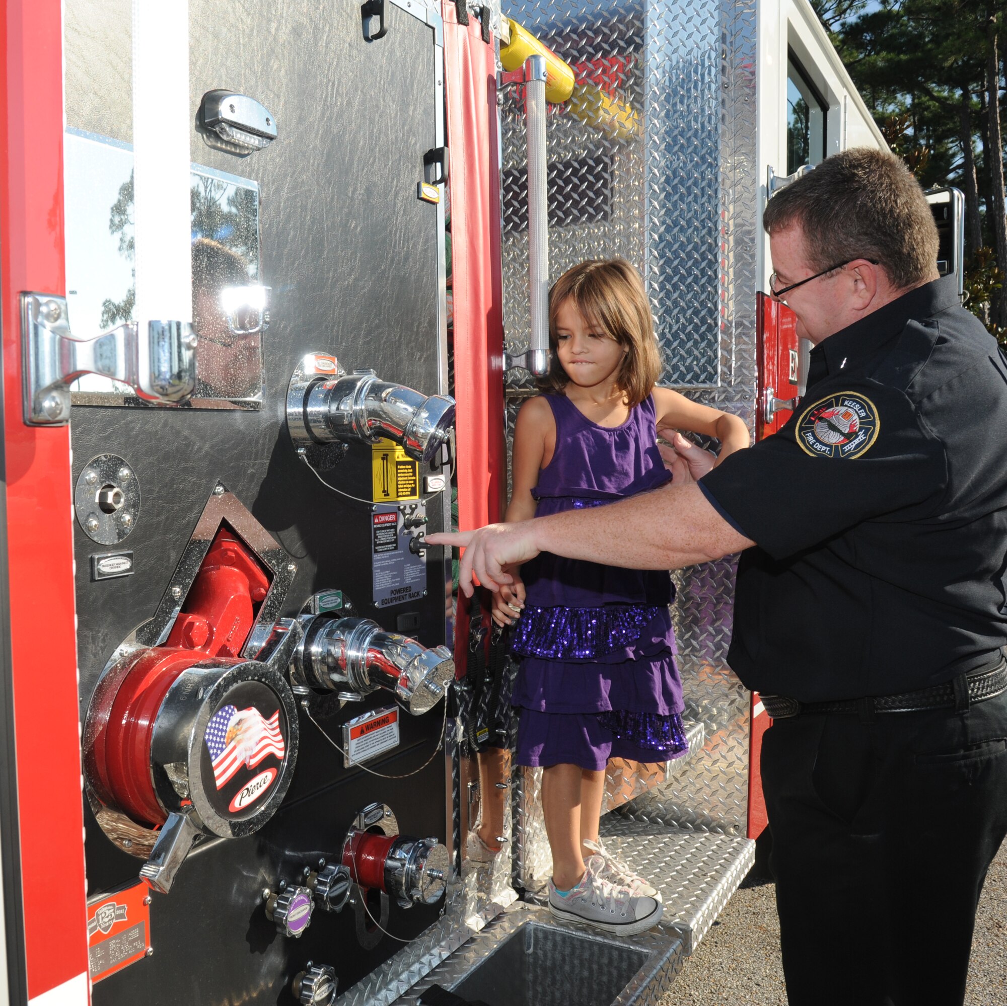 Four-year-old Olivia Crawford, daughter of Tracy and Tech. Sgt. Nathanael Crawford, 334th Training Squadron, receives a tour of a Keesler fire tuck from Ron Davis, 81st Infrastructure Division firefighter, during a visit from the fire department to the child development center Oct. 10, 2012, Keesler Air Force Base, Miss. Throughout fire prevention week the Keesler Fire Department conducted random fire drills, toured various facilities with Sparky the Fire Dog, passed out fire safety handouts and fire hats for children and provided stove and fire extinguisher demonstrations.  The week–long event will end with an open house at the fire station 10 a.m. to 2 p.m. Oct. 13.  (U.S. Air Force photo by Kemberly Groue)