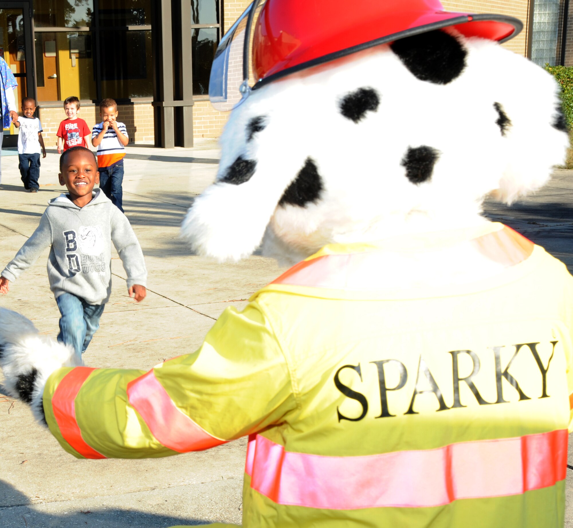 Three-year-old Jaylin Henley, son of Petty Officer 3rd Class James Henley, Naval Mobile Construction Betallion, Gulfport, Miss., and Airman 1st Class Crystal Henley, 81st medical Operations Squadron, runs to give Sparky the Fire Dog a hug Oct. 10, 2012, at the child development center, Keesler Air Force Base, Miss., during a visit from the Keesler Fire Department for fire prevention week.  Throughout fire prevention week the Keesler Fire Department conducted random fire drills, toured various facilities with Sparky the Fire Dog, passed out fire safety handouts and fire hats for children and provided stove and fire extinguisher demonstrations.  The week–long event will end with an open house at the fire station 10 a.m. to 2 p.m. Oct. 13.  (U.S. Air Force photo by Kemberly Groue)