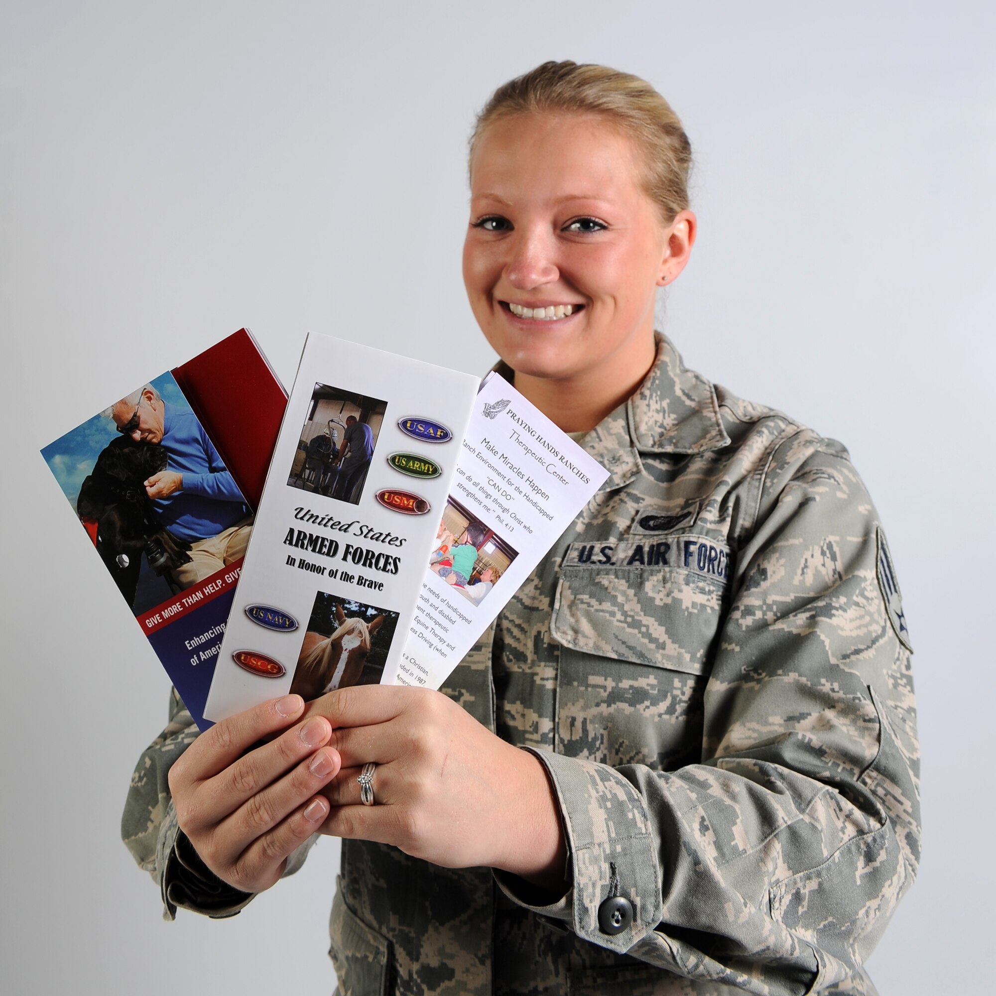 BUCKLEY AIR FORCE BASE, Colo. – Senior Airman Amy McMillan poses with pamphlets of the organizations she donated to for the 2012 Combined Federal Campaign. “I donate to Praying Hands Ranch and Freedom Service Dogs to help those people that have come back disabled from overseas,” McMillan said. (U.S. Air Force photo by Senior Airman Paul Labbe)