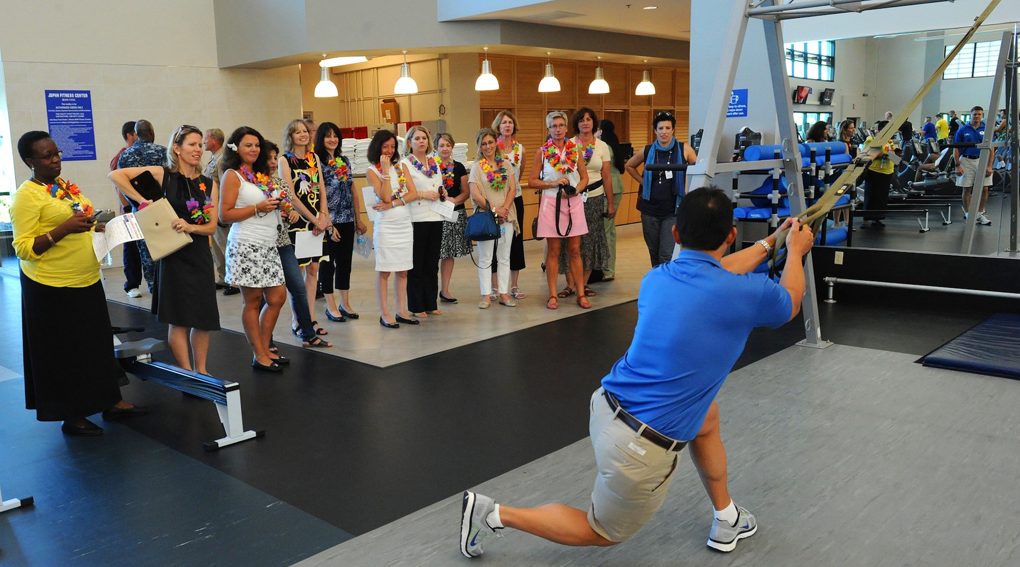 Benny Miguel, Pearl Harbor Fitness Center manager, demonstrates the use of a total resistance exercise strap available to service members in remote areas of the area of responsibility to foreign attaché corps spouses at the Pearl Harbor Fitness Center, Joint Base Pearl Harbor-Hickam, Hawaii, Oct. 9, 2012. Lt. Gen. Frank Gorenc, U.S. Air Force assistant vice chief of staff, hosted the tour which is meant to showcase how the U.S. Air Force conducts business.  The tour for the spouses highlighted how PACAF houses its forces, develops Airmen’s dependent children and cares for wounded members, common topics among the world’s militaries. (U.S. Air Force Photo/Tech. Sgt. Jerome S. Tayborn/Released)