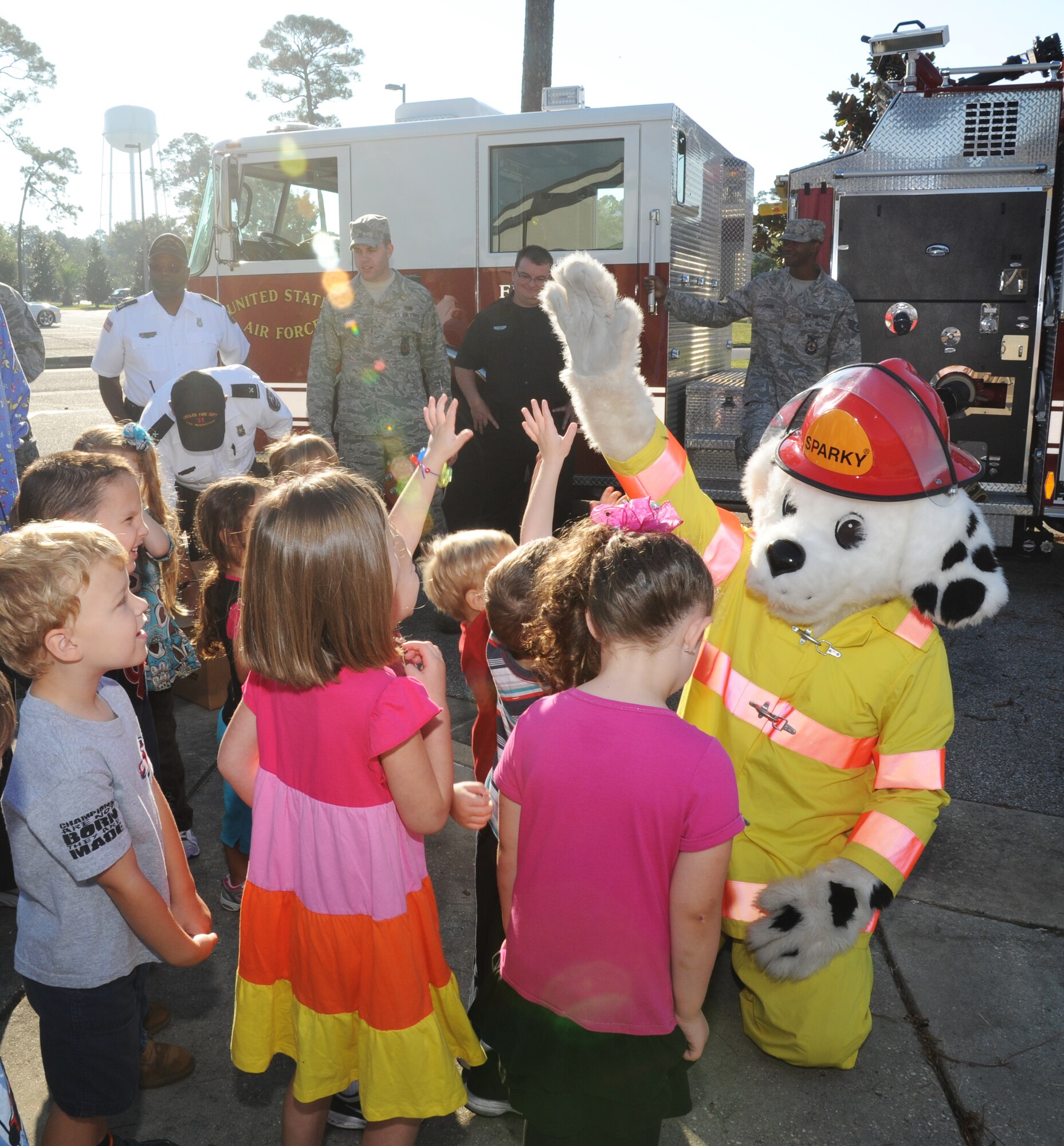 Children at the child development center receives high-fives from Sparky the Fire Dog Oct. 10, 2012, during a visit from the Keesler Fire Department for fire prevention week at Keesler Air Force Base, Miss. Throughout fire prevention week the Keesler Fire Department conducted random fire drills, toured various facilities with Sparky the Fire Dog, passed out fire safety handouts and fire hats for children and provided stove and fire extinguisher demonstrations.  The week–long event will end with an open house at the fire station 10 a.m. to 2 p.m. Oct. 13.  (U.S. Air Force photo by Kemberly Groue)
