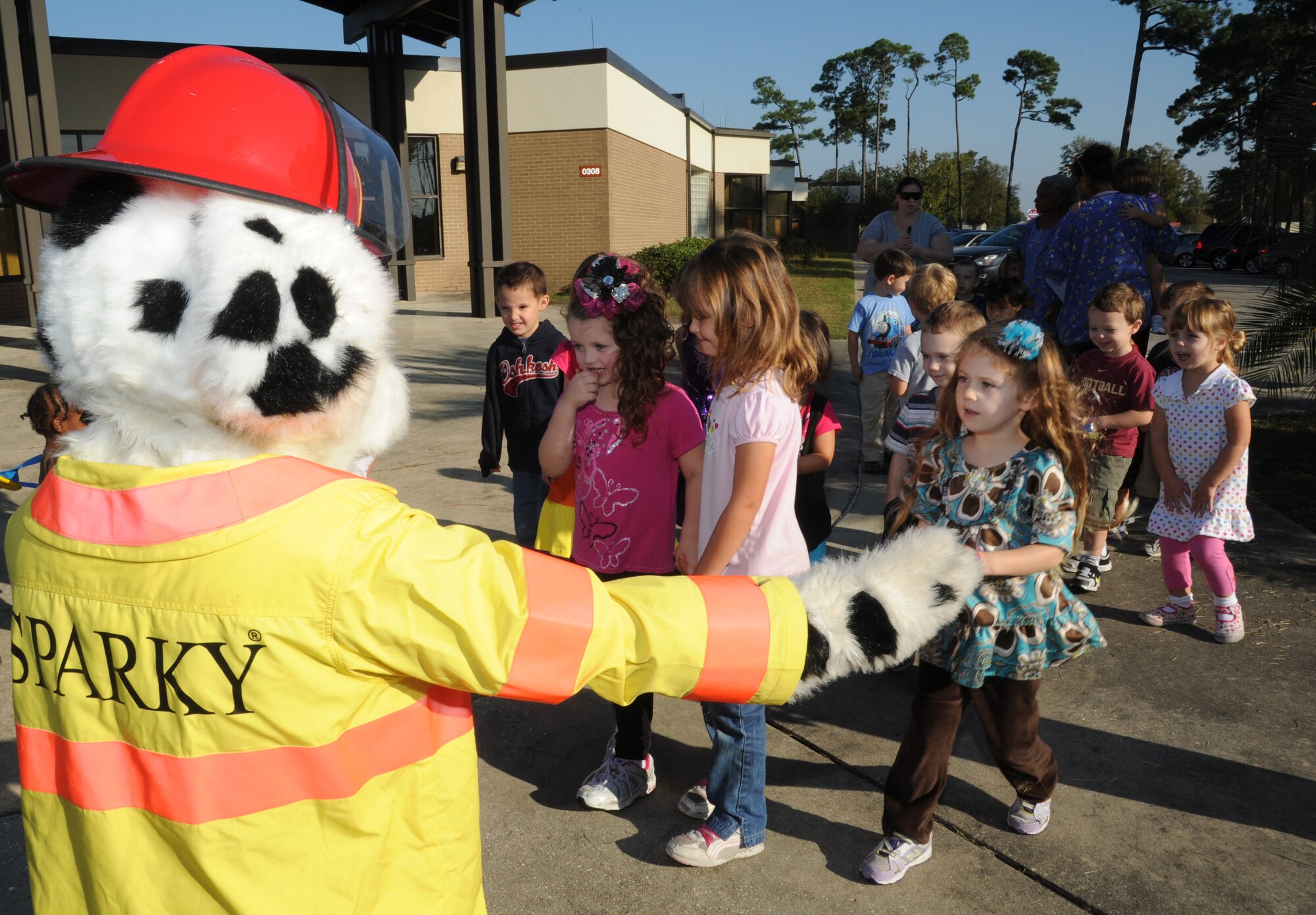 Children at the child development center are welcomed with open arms from Sparky the Fire Dog Oct. 10, 2012, during a visit from the Keesler Fire Department for fire prevention week at Keesler Air Force Base, Miss. Throughout fire prevention week the Keesler Fire Department conducted random fire drills, toured various facilities with Sparky the Fire Dog, passed out fire safety handouts and fire hats for children and provided stove and fire extinguisher demonstrations.  The week–long event will end with an open house at the fire station 10 a.m. to 2 p.m. Oct. 13.  (U.S. Air Force photo by Kemberly Groue)