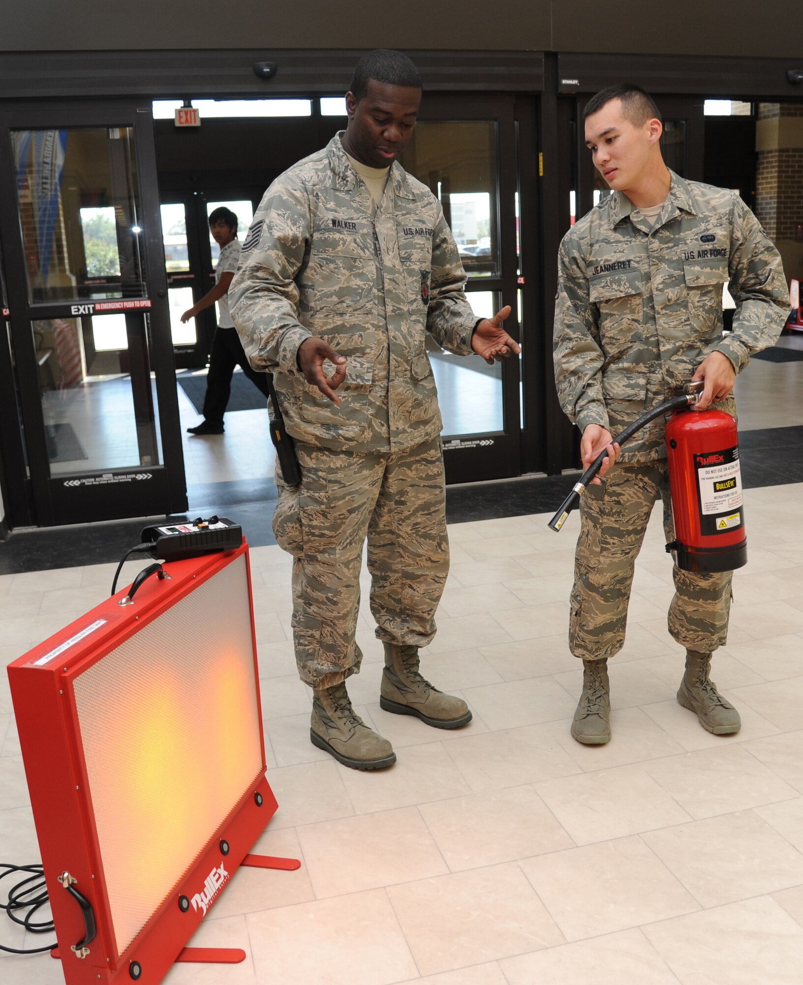 Tech. Sgt. Donald Walker, Keesler firefighter, goes through the fire safety steps with Airman 1st Class Austin Jeanneret, 333rd Training Squadron, using a fire extinguisher and a simulated fire, Oct. 9, 2012, inside the Exchange at Keesler Air Force Base, Miss.  Throughout fire prevention week the Keesler Fire Department conducted random fire drills, toured various facilities with Sparky the Fire Dog, passed out fire safety handouts and fire hats for children and provided stove and fire extinguisher demonstrations.  The week–long event will end with an open house at the fire station 10 a.m. to 2 p.m. Oct. 13.  (U.S. Air Force photo by Kemberly Groue)