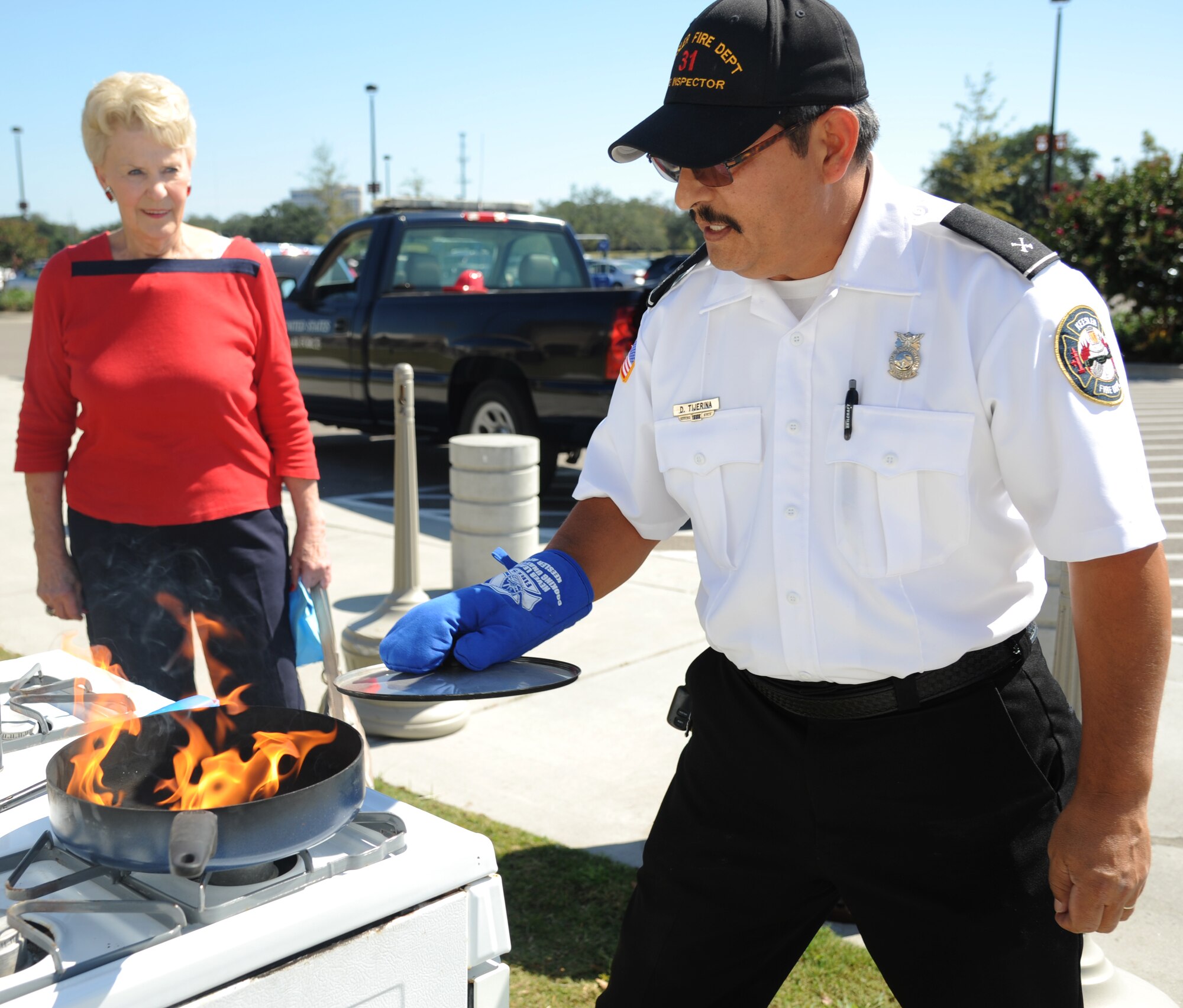 Shirley Shepard, retired spouse of deceased Coast Guardsman, watches a stove fire demonstration by David Tijerina, 81st Infrastructure Division firefighter, Oct. 9, 2012, outside the Exchange at Keesler Air Force Base, Miss.  Throughout fire prevention week the Keesler Fire Department conducted random fire drills, toured various facilities with Sparky the Fire Dog, passed out fire safety handouts and fire hats for children and provided stove and fire extinguisher demonstrations.  The week–long event will end with an open house at the fire station 10 a.m. to 2 p.m. Oct. 13.  (U.S. Air Force photo by Kemberly Groue)