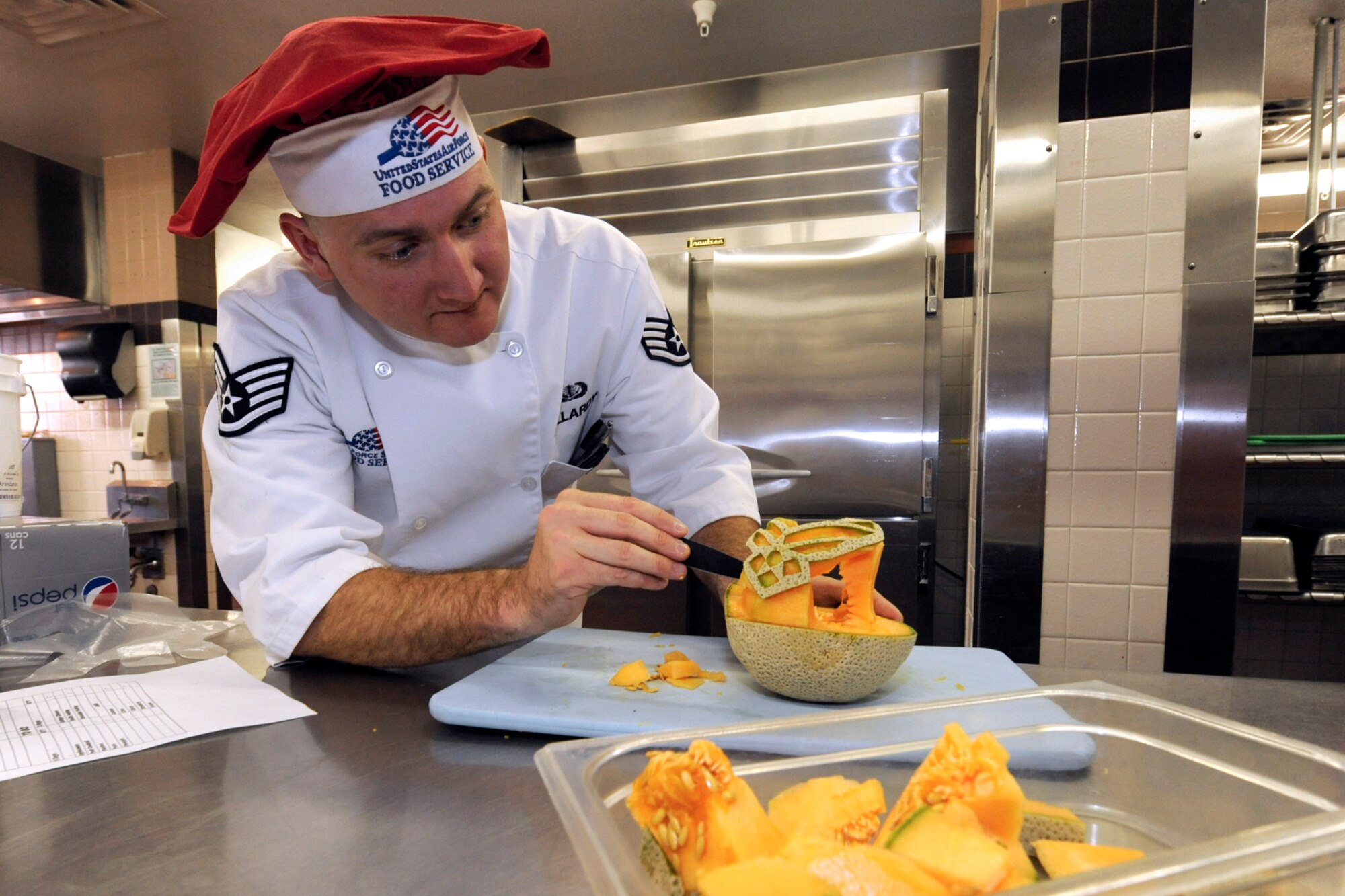 Staff Sgt. Joshua Pallardy, evening shift supervisor at the Aragon Dining Facility, sculpts food for service at the Aragon. Pallardy believes something as simple as cutting vegetables differently, as he did in a recent knife cutting demo, cues the brain to think the food tastes different.
