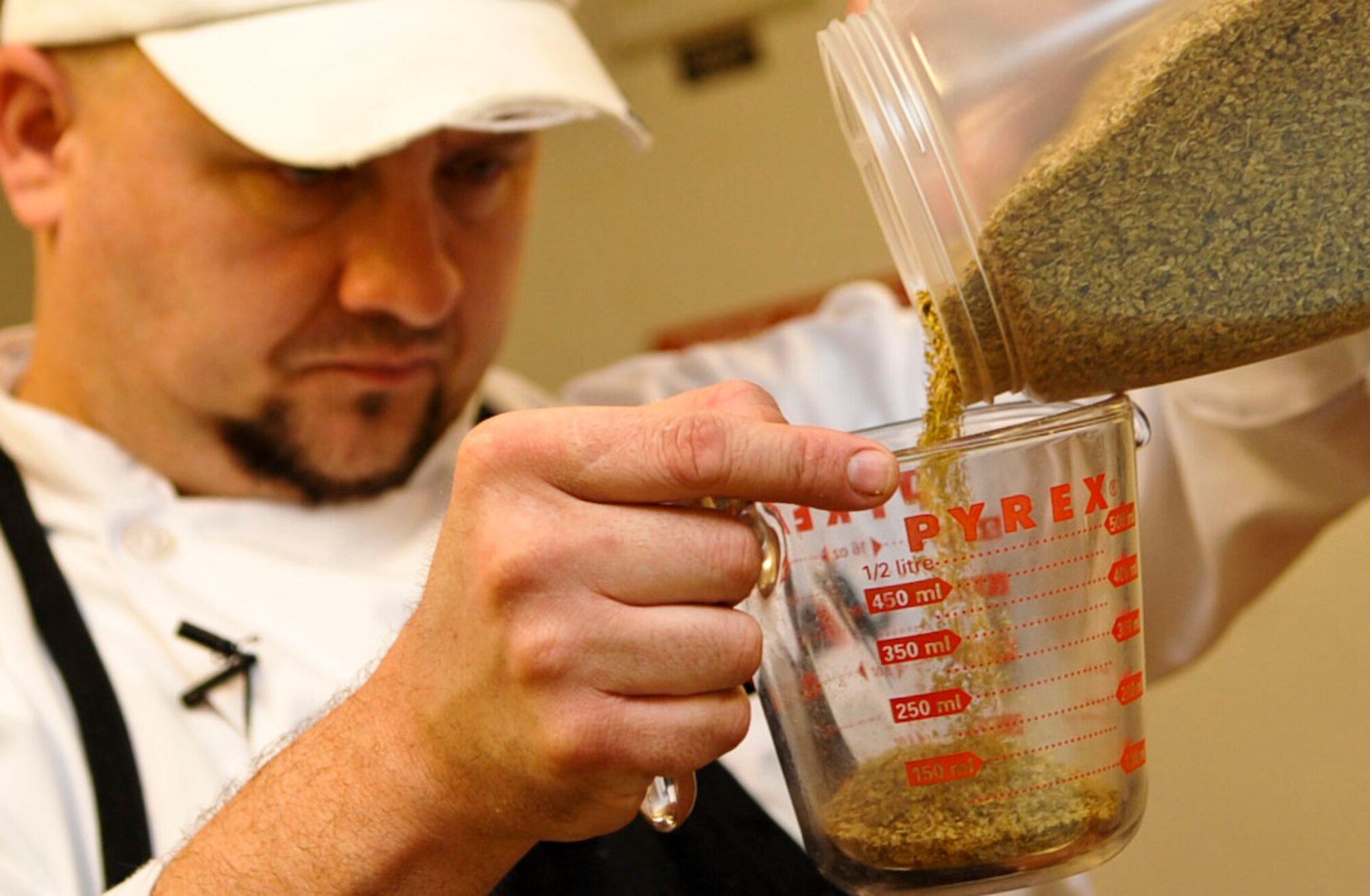 Tim Cooper, Fort Eustis Club executive chef, measures out an ingredient for a fresh batch of rolls for the lunch buffet at the club on Fort Eustis, Va., Oct. 10, 2012. Cooper is the new executive chef of the club, which has experienced a 35 percent increase in business since his arrival. (U.S. Air Force photo by Staff Sgt. Wesley Farnsworth/Released)