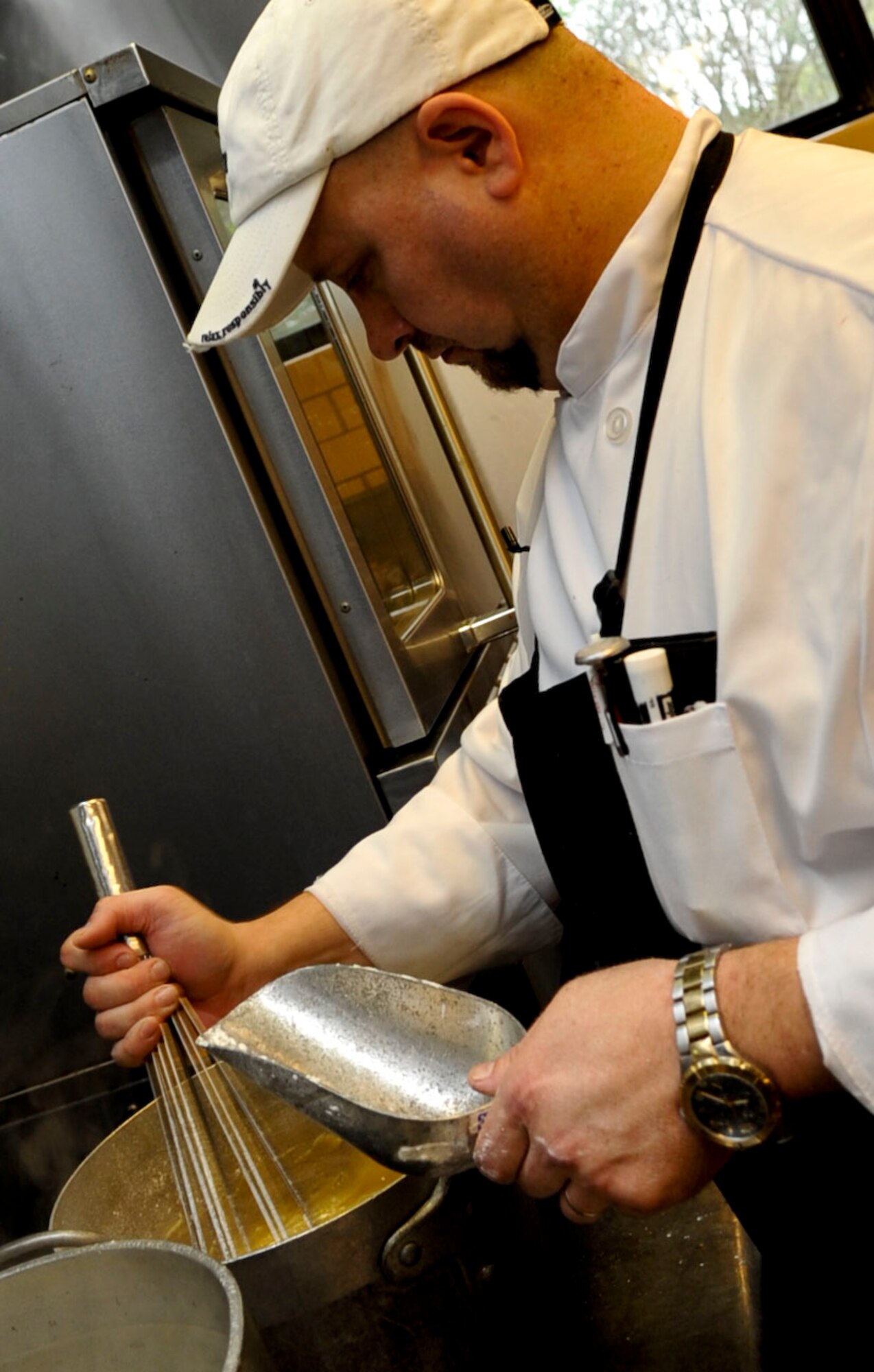 Tim Cooper, Fort Eustis Club executive chef, prepares food for the club's lunch buffet in the kitchen at Fort Eustis, Va., Oct. 10, 2012. Cooper and his team make every dish served at the club from scratch each day. (U.S. Air Force photo by Staff Sgt. Wesley Farnsworth/Released)