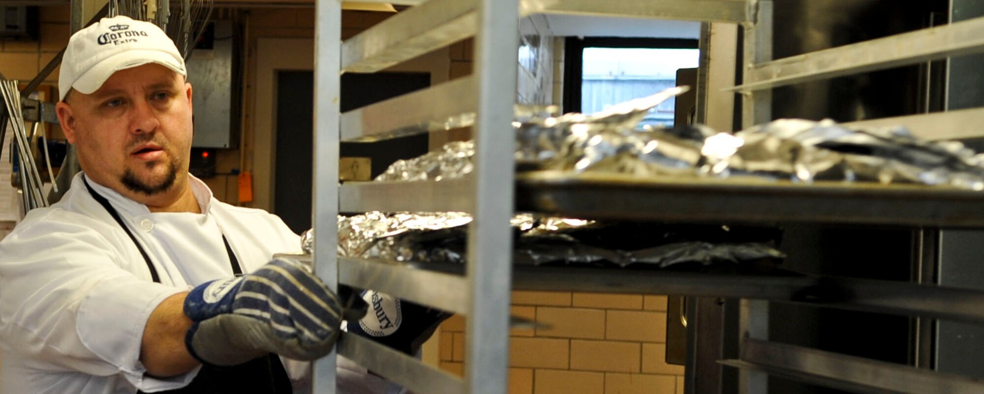 Tim Cooper, Fort Eustis Club executive chef, moves a cart of food in the club's kitchen at Fort Eustis, Va., Oct. 10, 2012. Cooper and his team prepare the club's buffet lunch offerings each day from scratch. (U.S. Air Force photo by Staff Sgt. Wesley Farnsworth/Released)