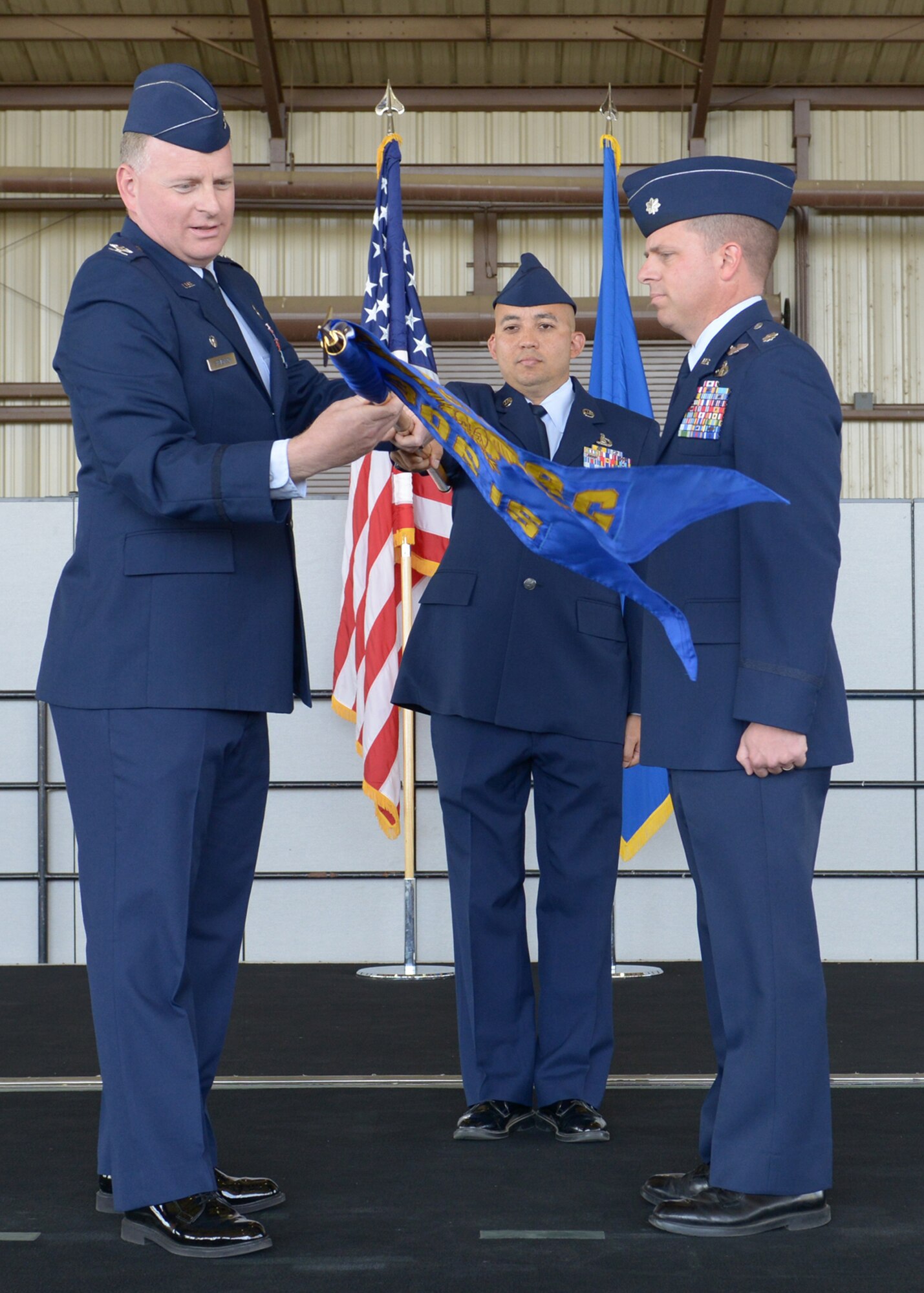 BEALE AIR FORCE BASE, Calif. -- Col. Michael Stevenson (left), 361st Intelligence, Surveillance and Reconnaissance Group commander, unfurls the 306th Intelligence Squadron flag for its new commander Lt. Col. Robb Rigtrup, signifying the activation of the squadron here Oct. 5. The newly activated squadron is a partner unit at Beale and falls under the 361st ISRG at Hurlburt Field, Fla. (U.S. Air Force photo by John Schwab)