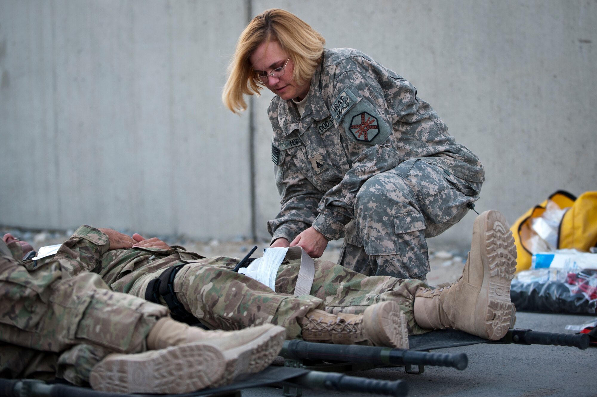 A Dept. of Defense civilian treats a role-layer’s simulated injuries during an emergency response exercise at Bagram Airfield, Afghanistan, Oct. 12, 2012. Bagram emergency crews responded to a simulated massive casualty event involving dozens of volunteers experiencing a wide range of simulated injuries. (U.S. Air Force photo/Capt. Raymond Geoffroy)