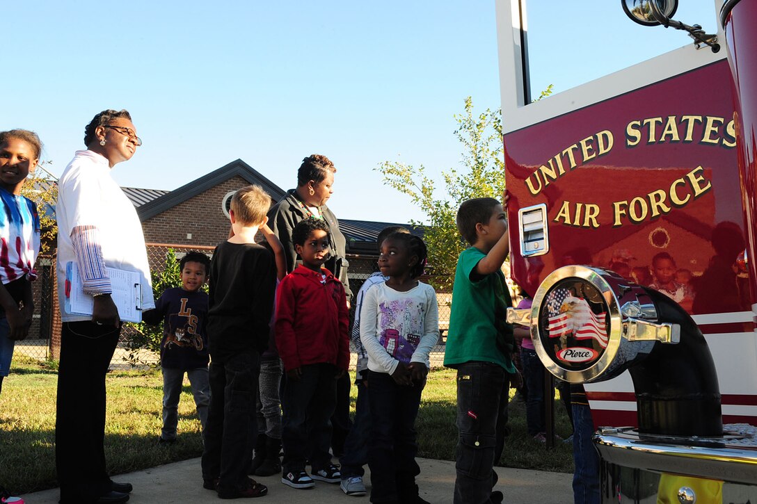 Children wait in line to view the inside of a fire truck during a Fire Prevention Week demonstration at the Bethel Youth Programs center, Hampton, Va., Oct. 11, 2012. The 633rd Civil Engineer Squadron firefighters visited various schools and child-care locations on-and-off base to inform children about fire prevention and safety tips. (U.S. Air Force photo by Staff Sgt. Ashley Hawkins/Released)