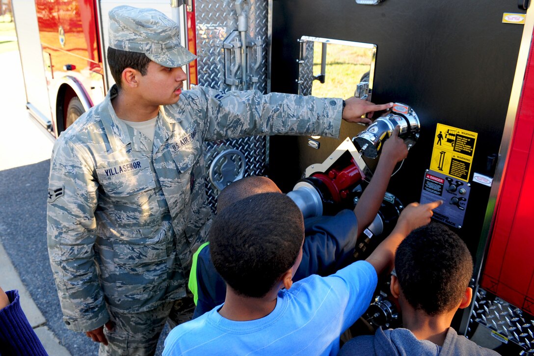 U.S. Air Force Airman 1st Class Chris Villasenor, 633rd Civil Engineer Squadron firefighter, explains the various configurations of a fire truck during a Fire Prevention Week demonstration at the Bethel Youth Programs center, Hampton, Va., Oct. 11, 2012. Personnel of Joint Base Langley-Eustis visited work-centers and family homes to promote fire prevention to Service members, civilians and their dependants. (U.S. Air Force photo by Staff Sgt. Ashley Hawkins/Released)