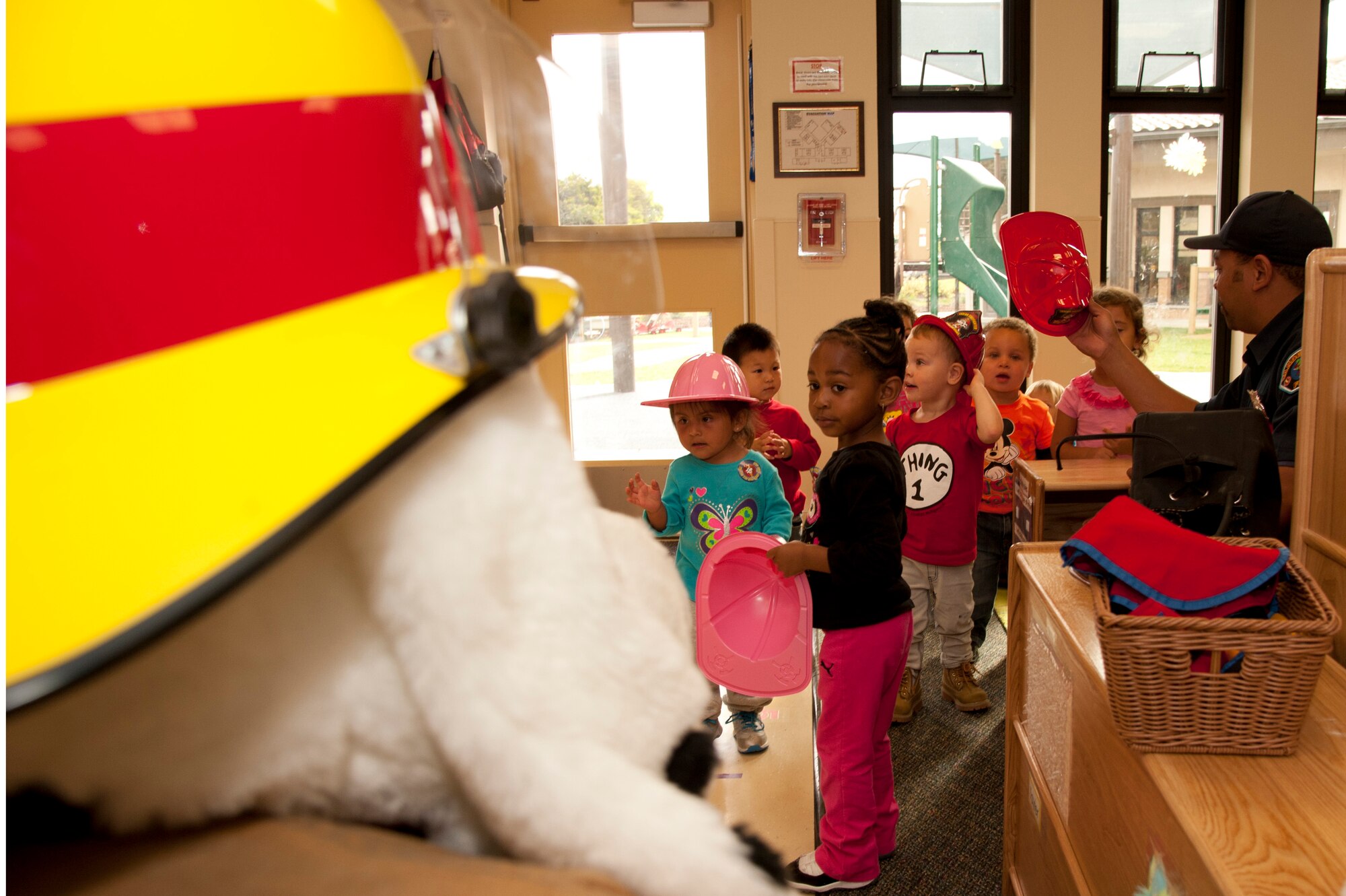 VANDENBERG AIR FORCE BASE, Calif. – Children at the Child Development Center receive plastic fire helmets and meet Sparky, Vandenberg Fire Department mascot, during a tour here Wednesday, Oct. 10, 2012. Sparky and Smokey the Bear visited the children to kick-off Fire Prevention Week on base. (U.S. Air Force photo/Senior Airman Lael Huss)
