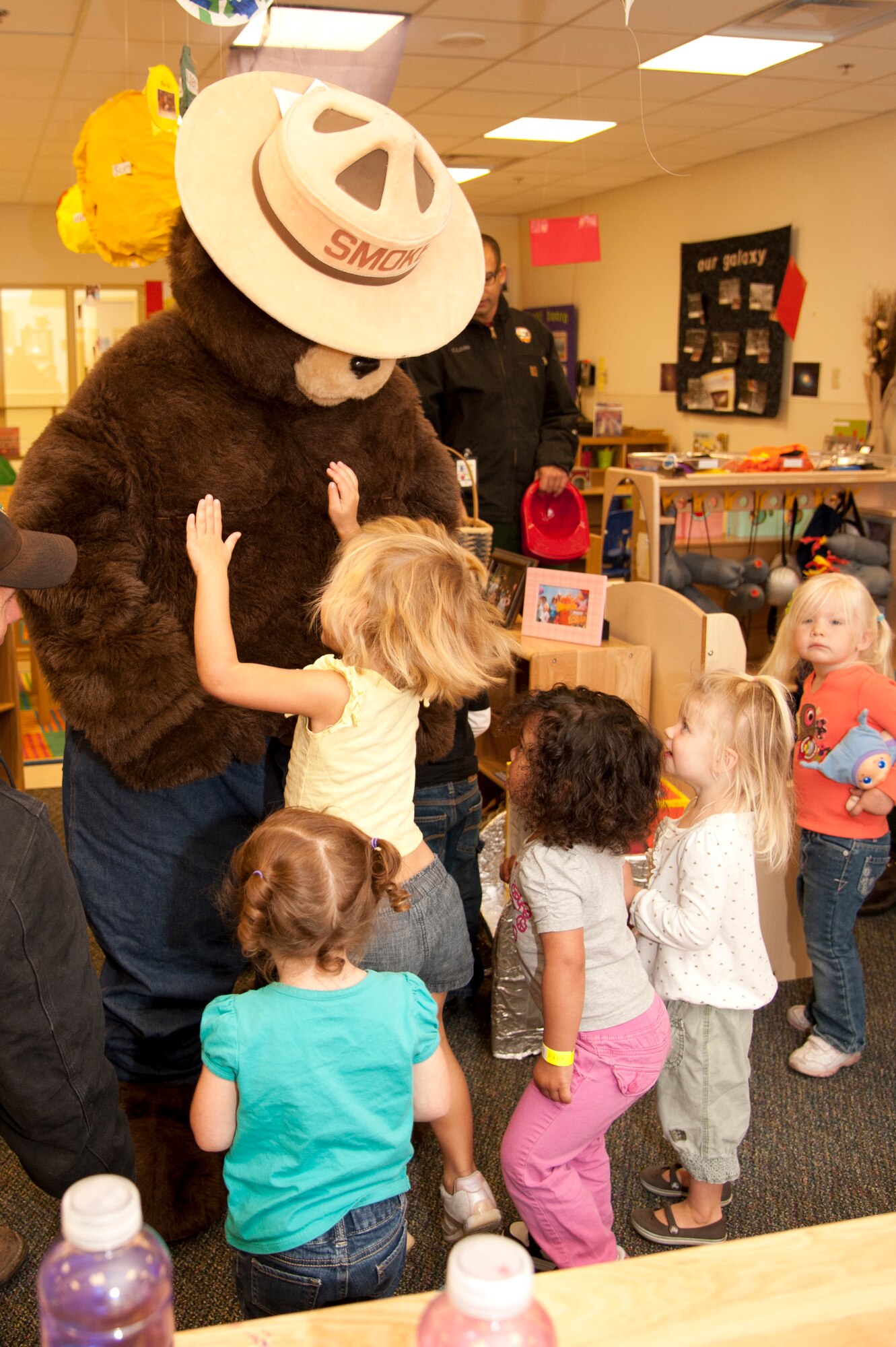 VANDENBERG AIR FORCE BASE, Calif. – Some children at the Child Development Center jump in excitement when they meet Smokey the Bear during the mascots tour here Wednesday, Oct. 10, 2012. Smokey the Bear and Sparky visited the CDC to kick-off Fire Prevention Week with events scheduled between October 7 and 13. (U.S. Air Force photo/Senior Airman Lael Huss)