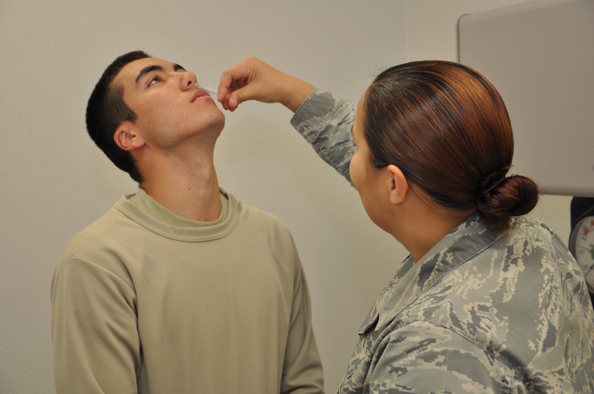 Staff Sgt. Kimberly Kretsch, 90th Medical Operations Squadron, administers a flu vaccine mist to Airman 1st Class Reid Bird, 90th Missile Security Forces Squadron, in the 90th Medical Group’s Immunizations Clinic Oct. 5. (U.S. Air Force photo by Senior Airman Dan Gage)