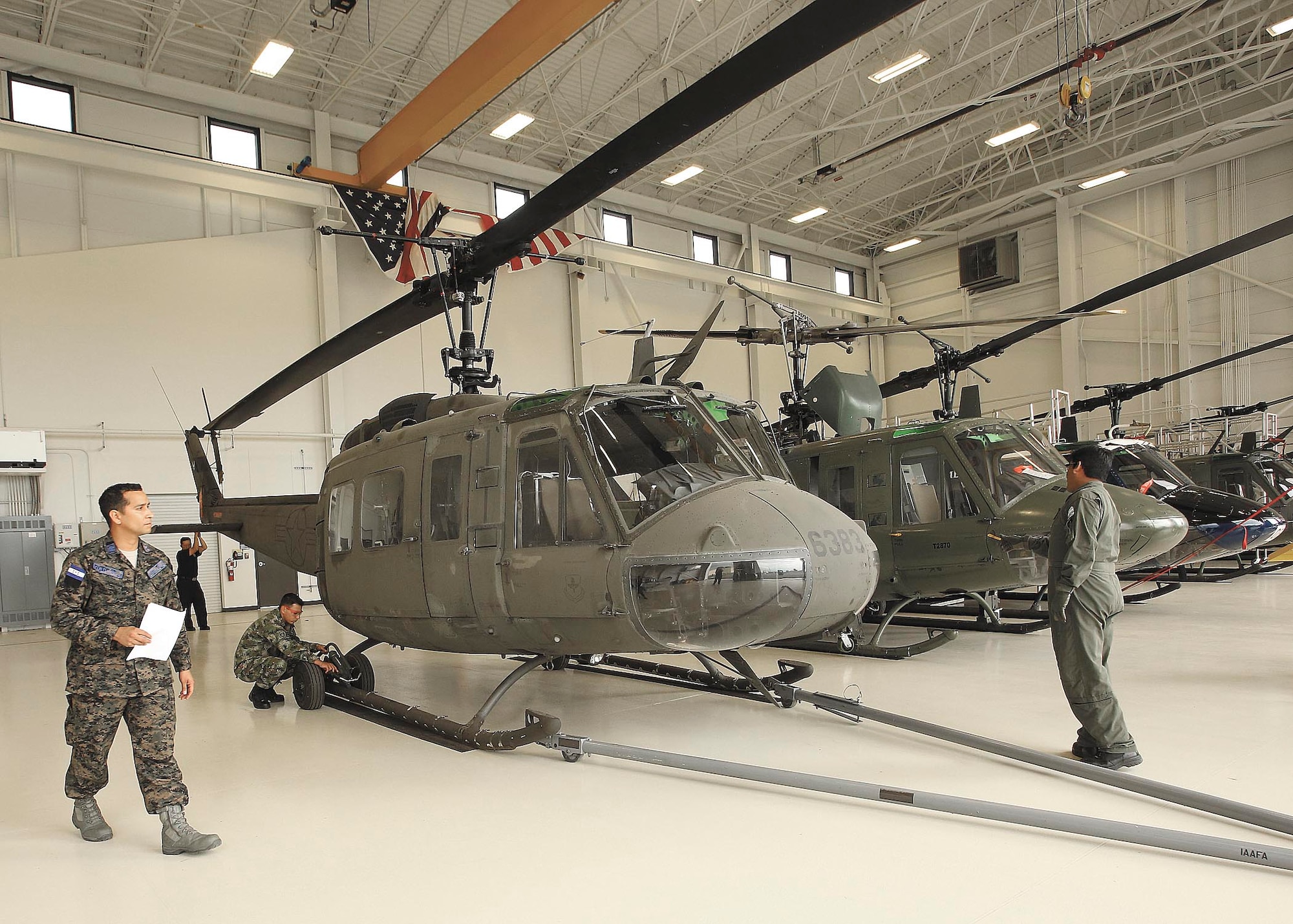 From left to right, guest instructor PNGI E-8 Mario Ordoñez, Honduras, O-2 Julio Hortiales, Mexico, E-1 Powell Murillo, Colombia, and E-6 Fernando Toscano, Argentina, prepare to move the UH-1H helicopter outdoors from inside the Inter-
American Air Forces Academy’s Airfi eld Training Complex High Bay Oct. 1. (U.S. Air Force photo/Robbin Cresswell)