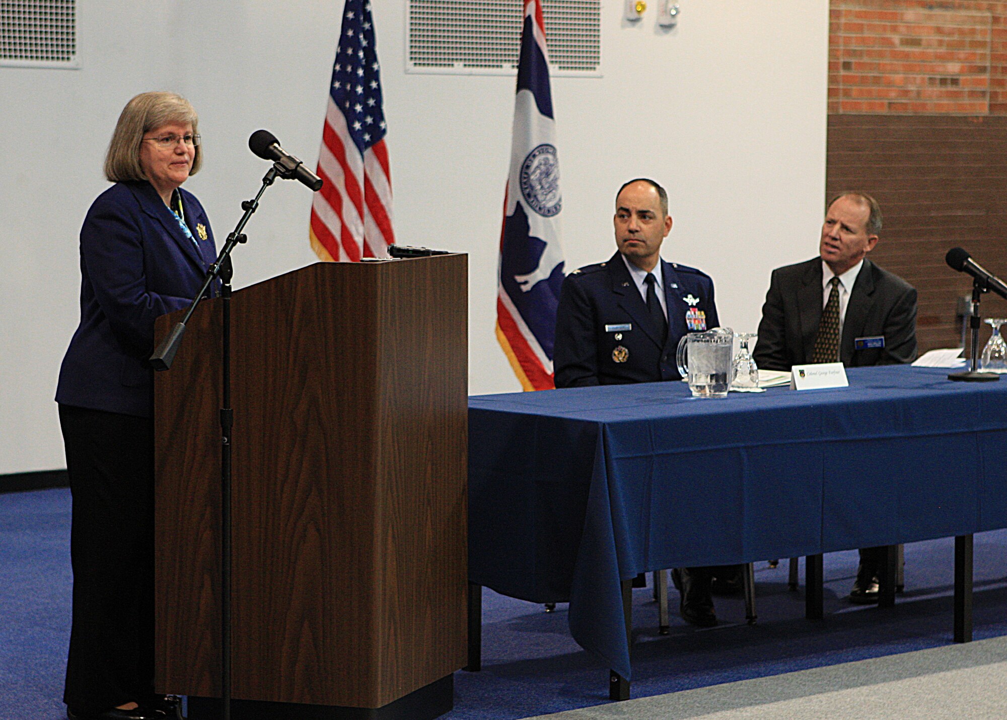 Holly Petraeus,  Servicemember Affairs Consumer Financial Protection Bureau assistant director, speaks to members of the  press  as Colonel George Farfour, 90th Missile Wing vice commander, and Gregory Phillips, Wyoming Attorney General, look on. The press conference was held at Fall Hall followed by a town hall meeting Oct. 3. (U.S. Air Force photo by Matt Bilden)