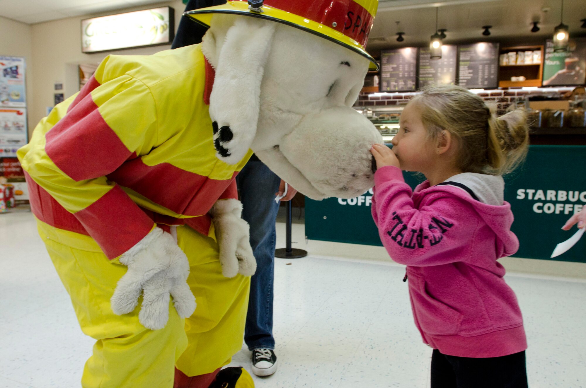 ROYAL AIR FORCE LAKENHEATH, England - Maggie Luetkemeyer, 7 year-old daughter of Betsy and Master Sgt. Matthew Luetkemeyer, 100th Civil Engineer Squadron, kisses Sparky the Fire Dog's nose at the RAF Lakenheath Exchange Oct. 11, 2012. Sparky the Fire Dog and 48th CES fire fighters visited the base exchange to raise awareness about fire safety as part of Fire Prevention Week. (U.S. Air Force photo by Staff Sgt. Stephen Linch) 