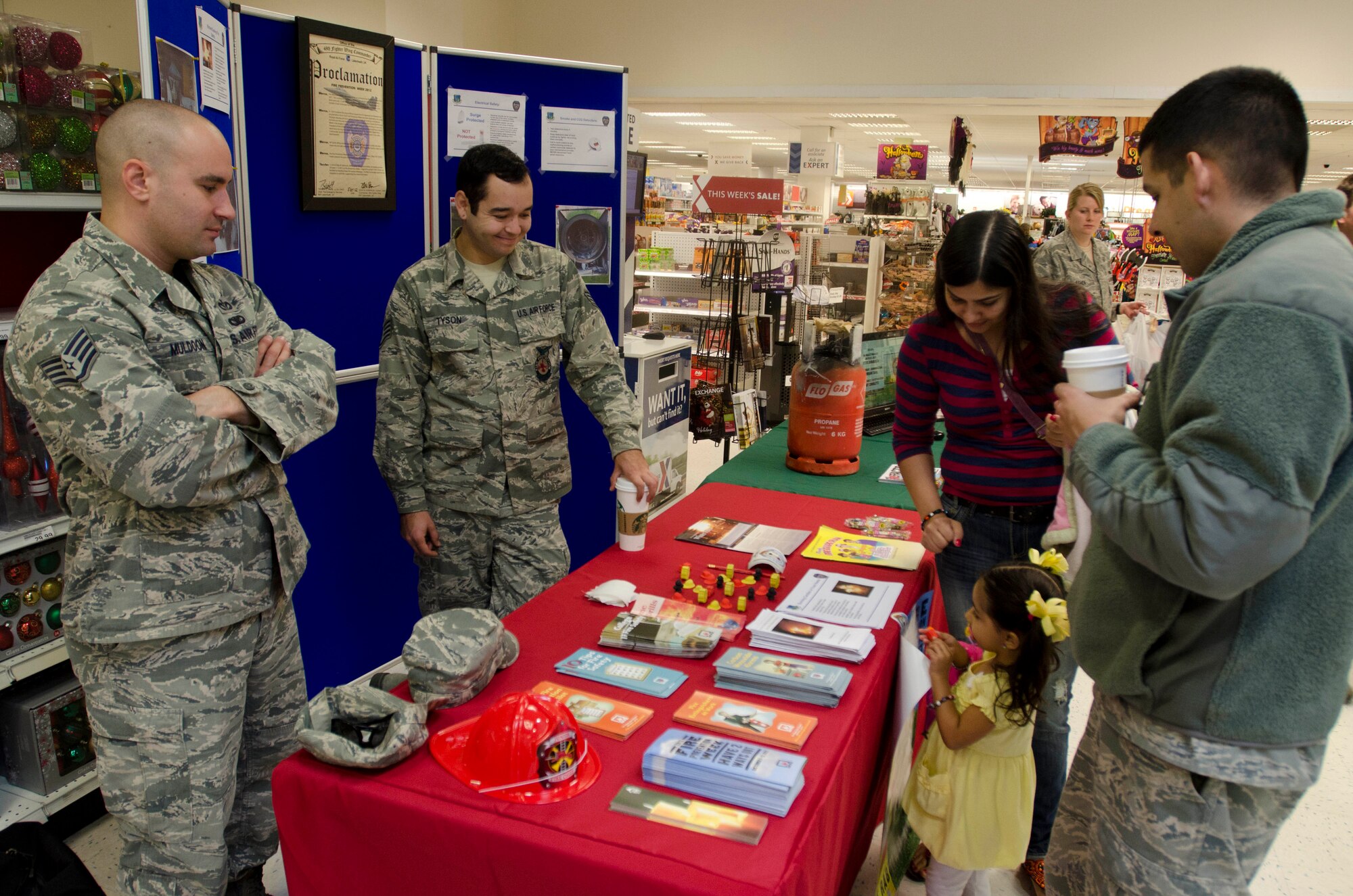 ROYAL AIR FORCE LAKENHEATH, England - Yamila Gonzalez, age 3, visits the Fire Prevention Week booth with her parents, Yalimar and Senior Airman Jonathan Gonzalez, 48th Component Maintenance Squadron, at the RAF Lakenheath Exchange Oct. 11, 2012. Sparky the Fire Dog and 48th Civil Engineer Squadron fire fighters visited the base exchange to raise awareness about fire safety as part of Fire Prevention Week. (U.S. Air Force photo by Staff Sgt. Stephen Linch) 