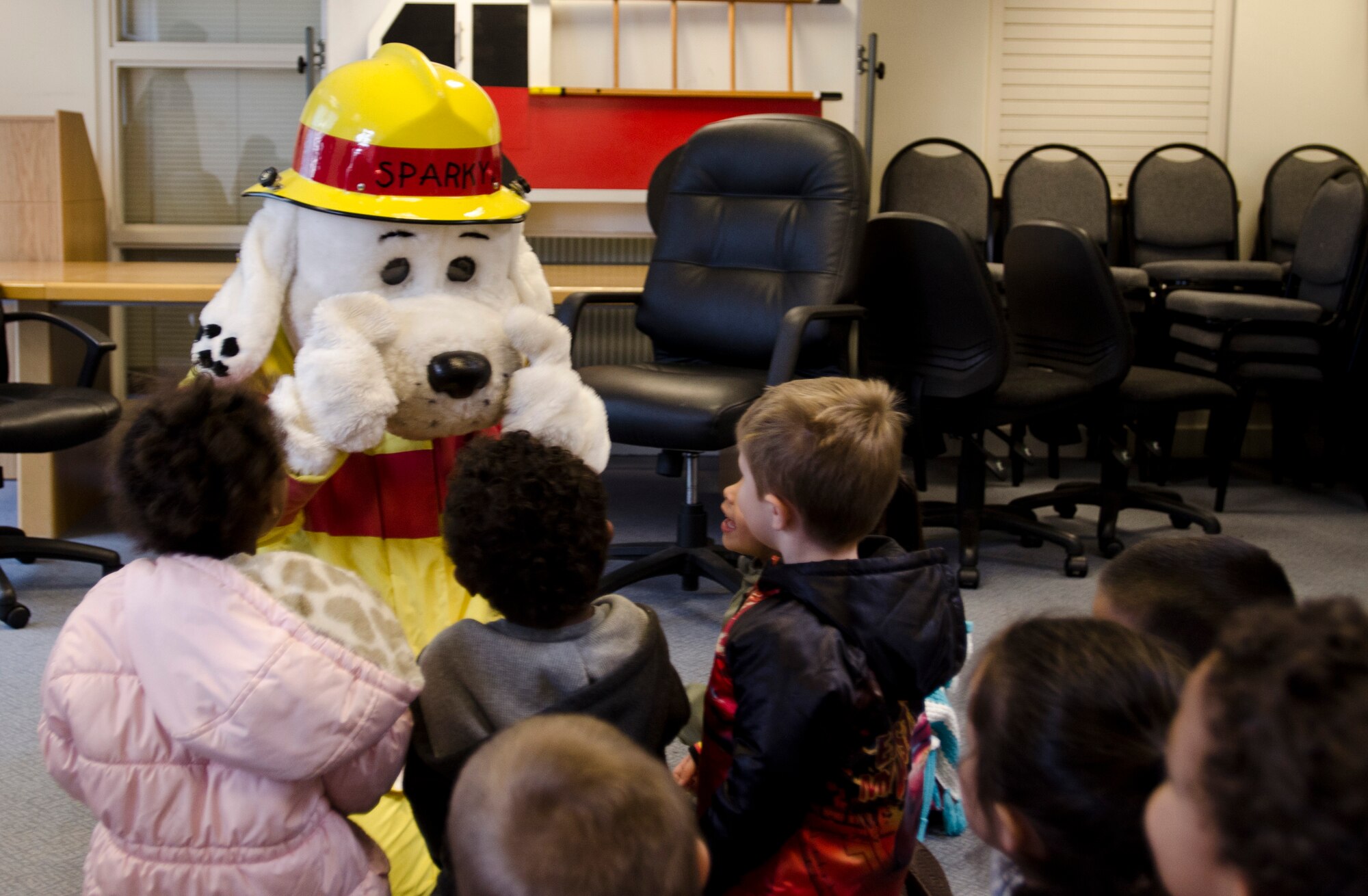 ROYAL AIR FORCE LAKENHEATH, England – Sparky the Fire Dog greets preschoolers from the Child Development Center West at the base library during Fire Prevention Week Oct. 11, 2012. Throughout the week, the 48th Civil Engineer Squadron firefighters coordinated a series of events to raise awareness and Liberty Wing members about fire prevention. (U.S. Air Force photo by Staff Sgt. Stephen Linch) 