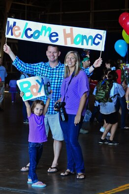 U.S. Navy Chief Mass Communication Specialist David Crawford, leading Chief Petty Officer Armed Forces Network Misawa, and his family hold up signs to welcome home their son from the Operation Children on Deployment Exercise at Misawa Air Base, Japan, Oct. 8, 2012.  Operation CODE allows military dependants to simulate a complete deployment process, ending with a homecoming event.  (U.S. Air Force photo by Staff Sgt. April Quintanilla)