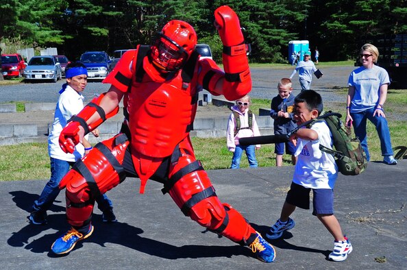 Members of 35th Security Forces Squadron give youth an opportunity to take down a perpetrator with batons during Operation Children on Deployment Exercise 2012 at Misawa Air Base, Japan, Oct. 8, 2012.  Operation CODE gives military dependants a glimpse of what their parents may encounter before, during and after deployments.  (U.S. Air Force photo by Staff Sgt. April Quintanilla)
