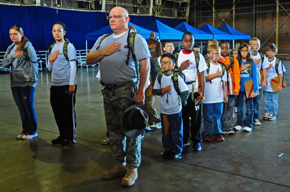 Volunteers and children hold their hands over their hearts during the American National Anthem prior to being deployed during Operation Children on Deployment Exercise at Misawa Air Base, Japan, Oct. 8, 2012.  Operation CODE is a chance for children between the ages 7 to 14 years old to experience events their parents go through in the military and is hosted by the Airman and Family Readiness Center.  (U.S. Air Force photo by Staff Sgt. April Quintanilla)