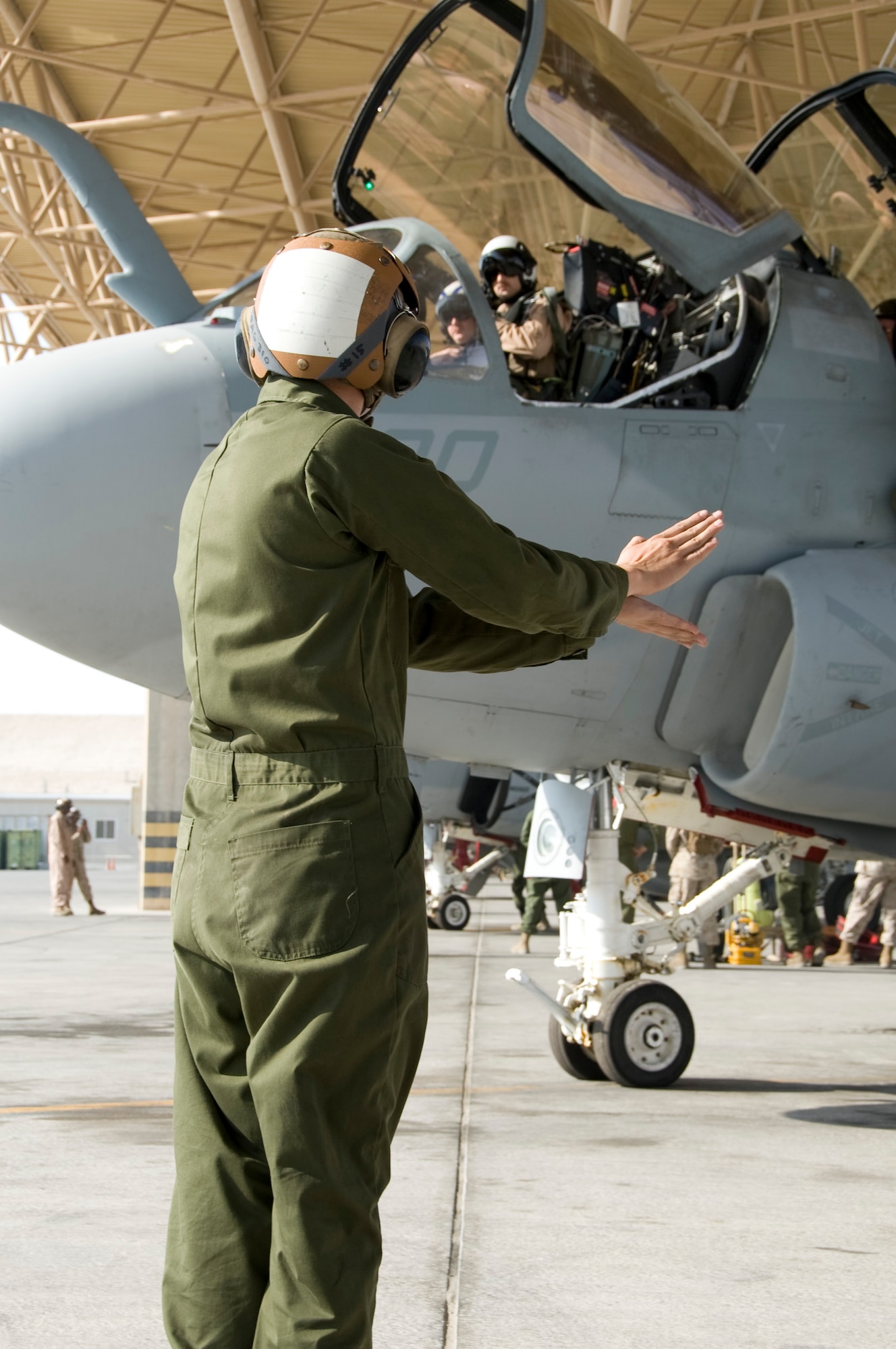Lance Cpl. Kristofer Gonzalez, Marine Tactical Electronic Warfare Squadron 3 plane captain, signals to the pilot prior to a launch Oct. 8, 2012 in Southwest Asia. The VMAQ-3 “MoonDogs” arrived here Sept. 25, in order to relieve the VMAQ-2 “Death Jesters.” All four of the Marine Corps’ Tactical Electronic Attack squadrons are based at Marine Corps Air Station Cherry Point, N.C. (U.S. Air Force photo/Senior Airman Bryan Swink)