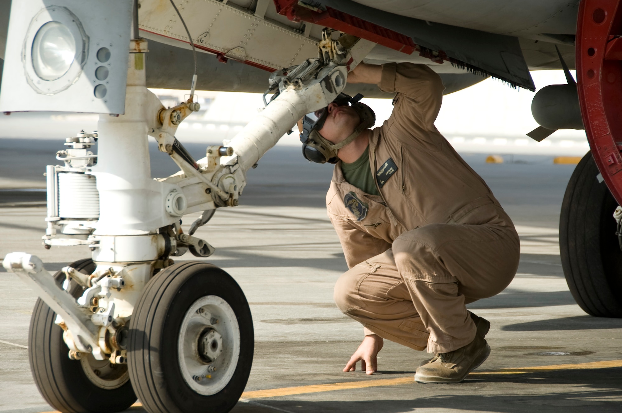 Corporal Daniel Swisher, Marine Tactical Electronic Warfare Squadron 3 plane captain, inspects the nose gear of the EA-6B Prowler during final checks prior to launch Oct. 8, 2012 in Southwest Asia. VMAQ-3 is an expeditionary squadron flying the EA-6B Prowler, a four-seat, twin-engine tactical electronic attack aircraft that provides radar and communications jamming capabilities. (U.S. Air Force photo/Senior Airman Bryan Swink)
