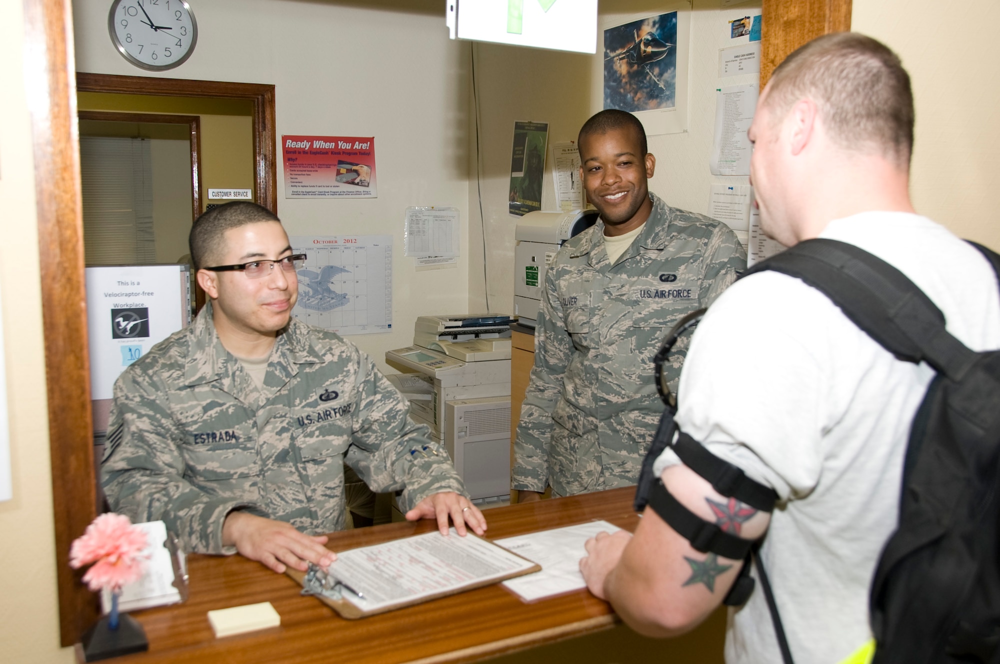 Staff Sergeants Eduardo Estrada (left) and Armond Oliver, 379th Expeditionary Comptroller Squadron customer service technicians, assist a customer in obtaining his EagleCash card shortly after his arrival to the 379th Air Expeditionary Wing Oct. 3, 2012. The customer service team supports individual customers across the installation, helping with filing travel accruals to pay government travel card balances or initiating pay entitlements. Since their rotation began in June, they have served more than 16,000 customers. Estrada is deployed from MacDill Air Force Base, Fla., and Oliver is deployed from Travis AFB, Calif. (U.S. Air Force photo/Senior Airman Bryan Swink)