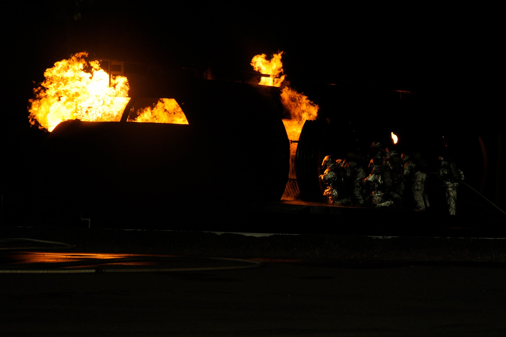 Firefighters from the 35th Civil Engineer Squadron assist wing leadership and distinguished visitors from the base with extinguishing a fire at a nighttime fire demonstration during Fire Prevention Week at Misawa Air Base, Japan, Oct. 10, 2012. Fire Prevention Week gives firefighters an opportunity to connect with the community without being on an emergency call. They also get to teach the community how to prevent fires and make a call for emergency help. (U.S. Air Force photo by Tech. Sgt. Marie Brown)

