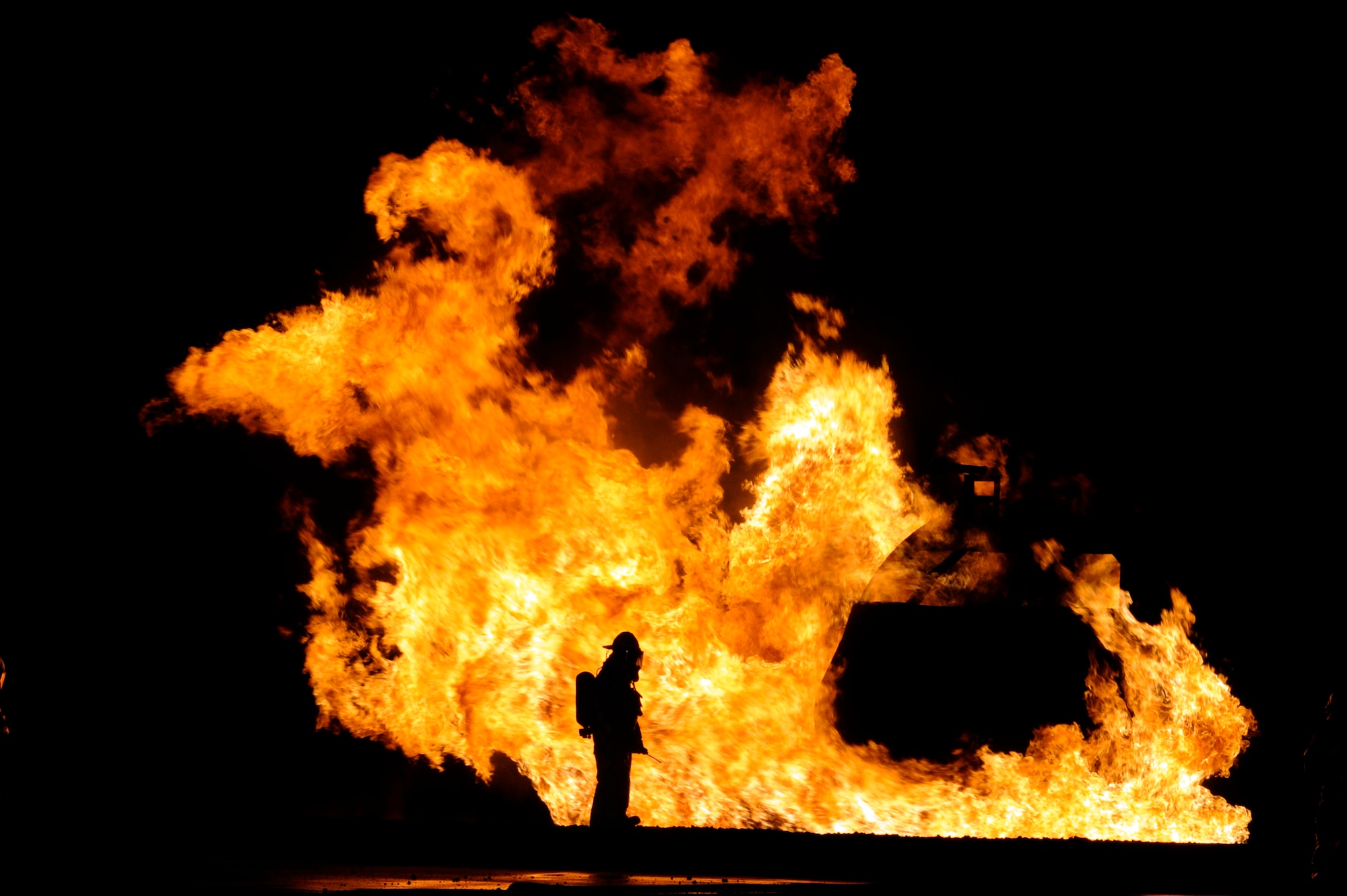 A firefighter from the 35th Civil Engineer Squadron stands next to a nighttime firefighting demonstration during Fire Prevention Week at Misawa Air Base, Japan, Oct. 10, 2012. Fire Prevention Week is typically held during the second week of October.  (U.S. Air Force photo by Tech. Sgt. Marie Brown)