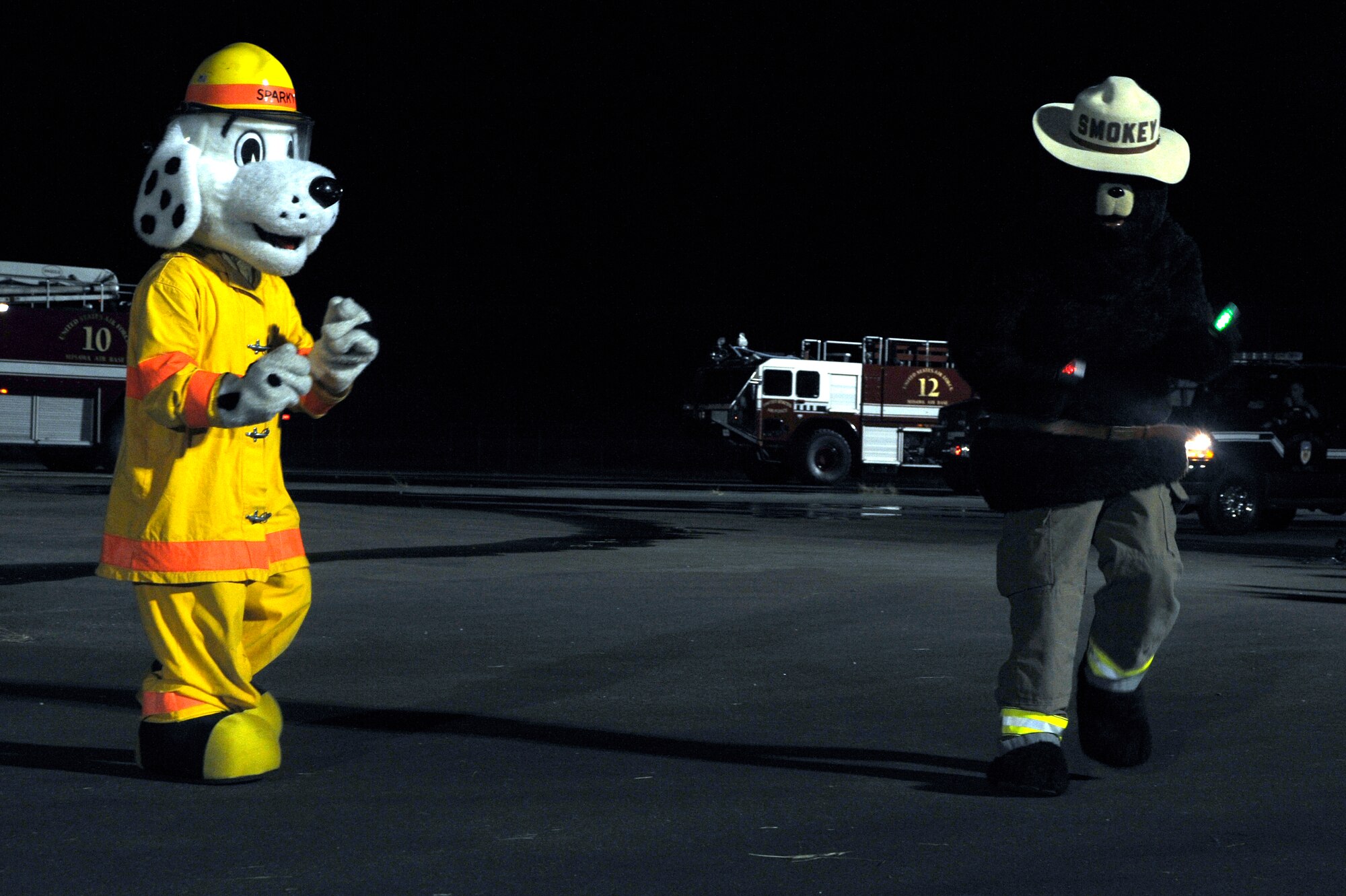 Sparky the Fire Dog and Smokey the Bear compete in a dance-off at a nighttime firefighting demonstration during Fire Prevention Week at Misawa Air Base, Japan, Oct. 10, 2012. Fire Prevention Week was established to commemorate the Great Chicago Fire, a tragic 1871 urban blaze that killed more than 250 people, left 100,000 people homeless, destroyed more than 17,400 structures and burned more than 2,000 acres. (U.S. Air Force photo by Tech. Sgt. Marie Brown)

