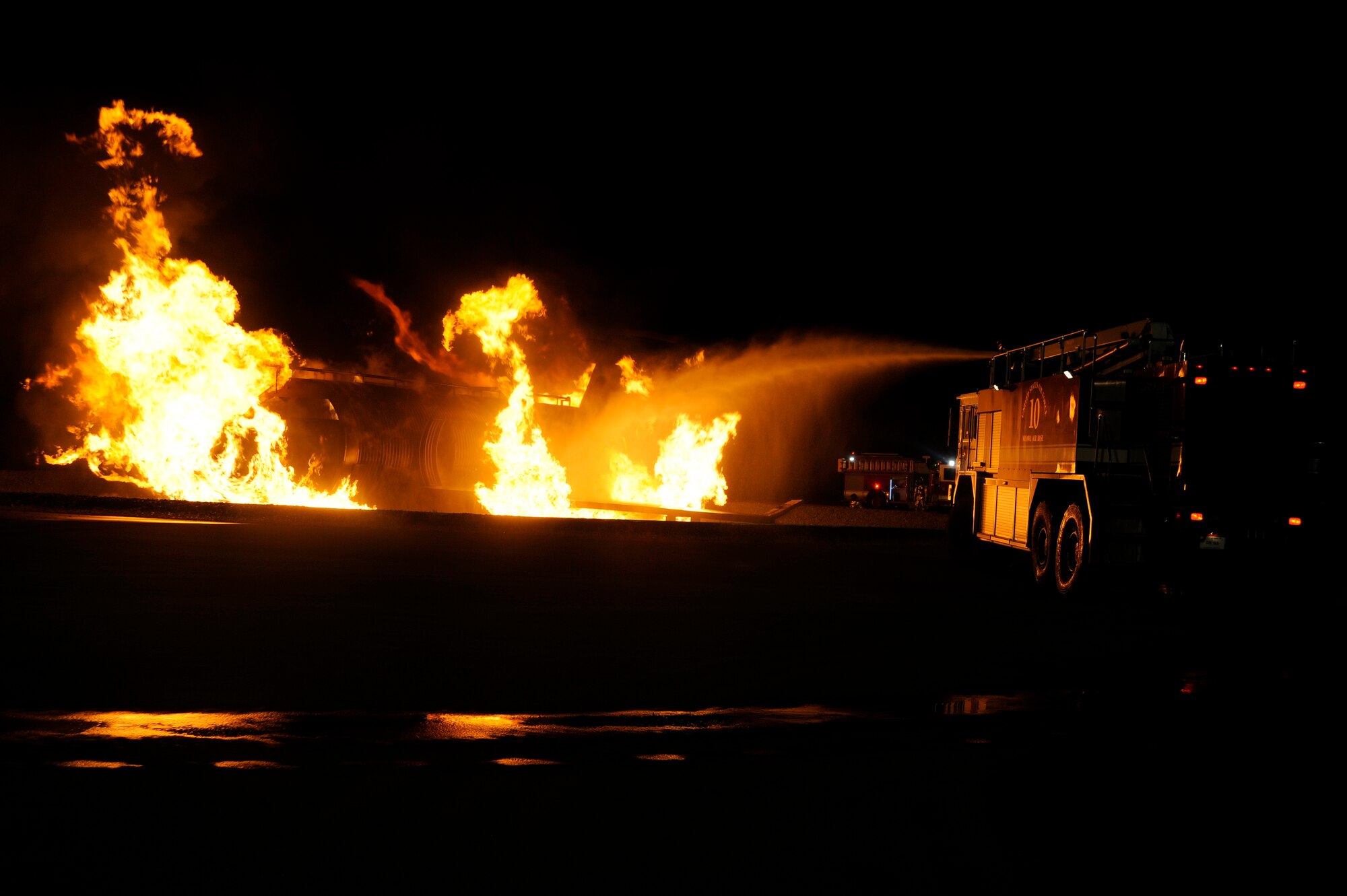 Firefighters from the 35th Civil Engineer Squadron demonstrate how to extinguish a fire during Fire Prevention Week at Misawa Air Base, Japan, Oct. 10, 2012. The 35 CES fire department invited the base community to watch a nighttime fire demonstration to help promote sound fire prevention, safety knowledge and a fire-safe lifestyle.  (U.S. Air Force photo by Tech. Sgt. Marie Brown)