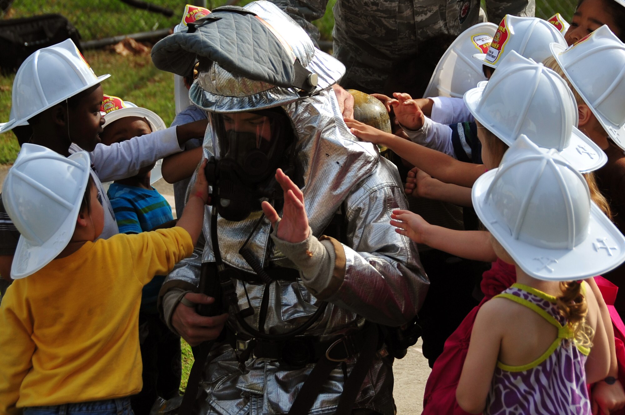 Airman 1st Class Mark Morris, 51st Civil Engineer Squadron firefighter, lets children from the career development center touch his gear during a demonstration at Osan Air Base, Republic of Korea, Oct. 9, 2012, to teach younger children not to be afraid of them during emergency situations. The 51st Civil Engineer Squadron firefighters are traveling to different organizations on base for Fire Prevention Week, Oct. 7-13. (U.S. Air Force photo/Staff Sgt. Craig Cisek)