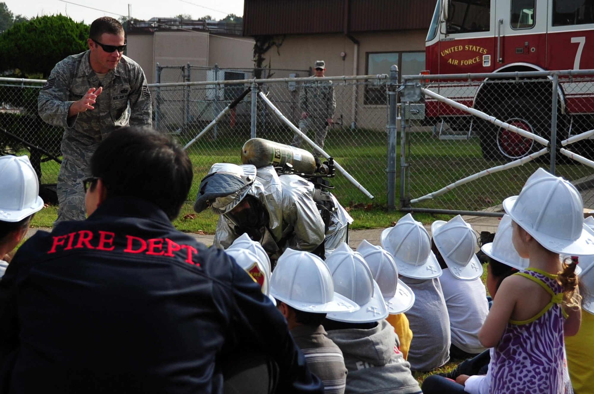 Tech. Sgt. Jason Layfield, 51st Civil Engineer Squadron firefighter, describes what firefighter’s wear when responding to a fire in a demonstration at Osan Air Base, Republic of Korea, Oct. 9, 2012. Every October, fire departments throughout the country host the fire education and awareness known as, Fire Prevention Week. This year’s theme is "Have Two Ways Out" encouraging families to reevaluate their exit strategies and incorporate a second exit. Fire Prevention Week was established to commemorate the Great Chicago Fire of 1871. (U.S. Air Force photo/Staff Sgt. Craig Cisek)