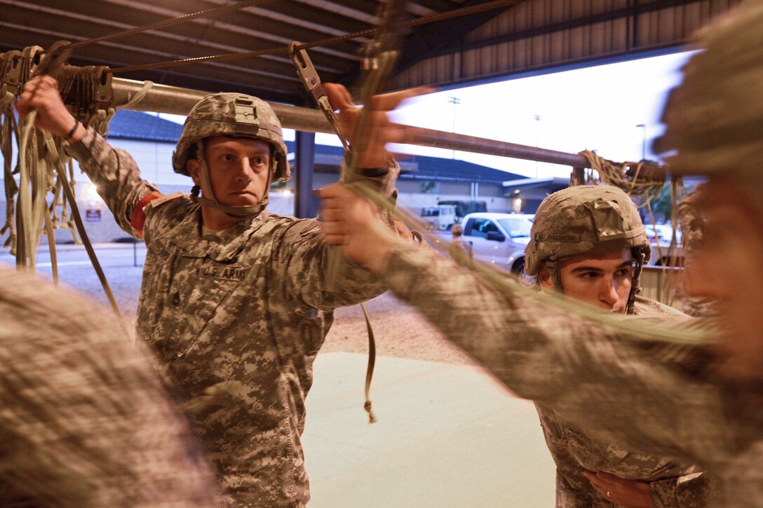 Army Sgt. 1st Class Robert A. Burd rakes static lines during mock-door training for paratroopers before an airborne operation on Pope Army Airfield, on Fort Bragg, N.C., Oct. 8, 2012. Burd, a jumpmaster, is assigned to the 82nd Airborne Division's 3rd Brigade Combat Team.