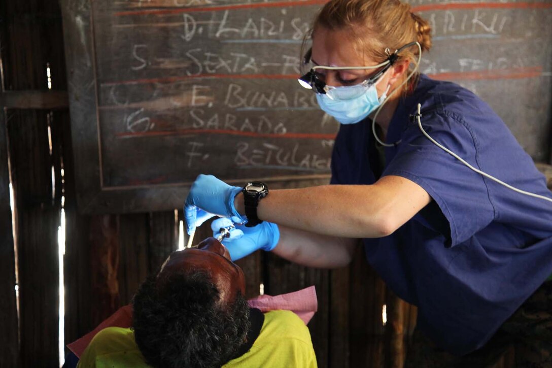 Petty Officer 2nd Class Anna Els, corpsman, Combat logistics Battalion 15, 15th Marine Expeditionary Unit, remove’s a patient’s tooth inside a school at a Timo-Leste village, Oct. 11, during Exercise Crocodilo 2012, the first exercise the 15th MEU and Peleliu Amphibious Ready Group has conducted during its Western Pacific deployment. During the exercise a total of 10 sights were visited in which corpsmen from the MEU  gave health screenings and vaccinations, made surgery referrals to a local hospital, provided dental care to include tooth removal, gave optometry screenings, prescribed and provided eyeglasses and issued medication and vitamins for minor illnesses or injuries. Els, 25,is from Ozark, Mo.